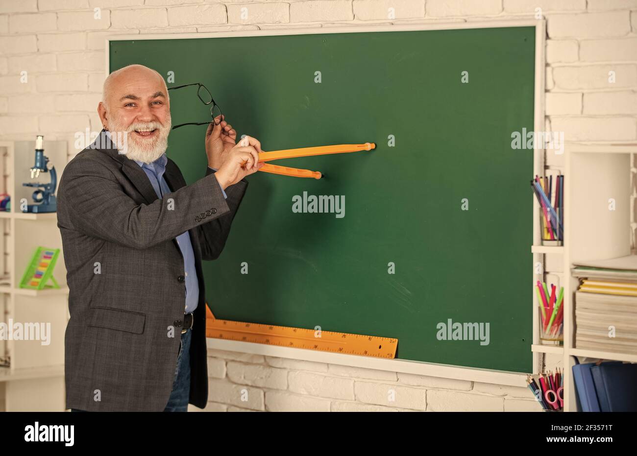 Nützliches Wissen. Bildungstrends. Adaptive Lernsysteme nutzen Daten passen Lernen individuelle Skala an. Senior intelligenter Mann Lehrer an der Tafel Stockfoto