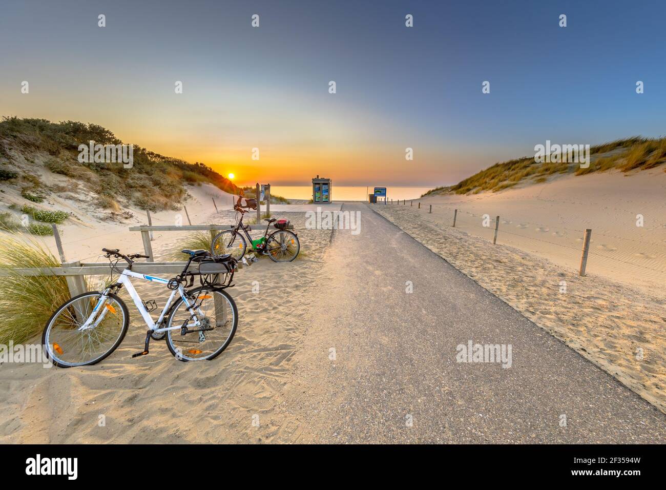 Fahrradkegel in Düne mit Sonnenuntergang über Nordsee und Kanal in Ouddorp, Zeeland Provinz, Niederlande geparkt. Outdoor-Szene der Küste in der Natur Europas Stockfoto