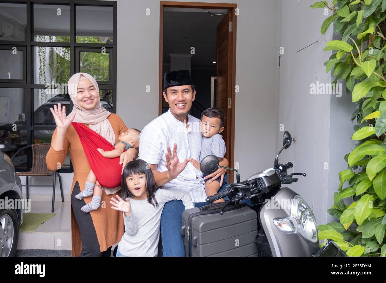 asiatische muslimische Familie Reiten Motorrad Roller zusammen mit Kind reisen Stockfoto