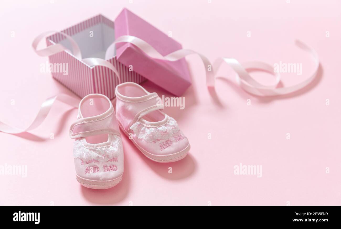 Babydusche, Mädchen Taufe Konzept. Baby rosa Schuhe auf rosa Farbe Hintergrund. Es ist ein Mädchen Neugeborenen Ankündigungsvorlage. Weiche weibliche Fußwea für Kleinkinder Stockfoto