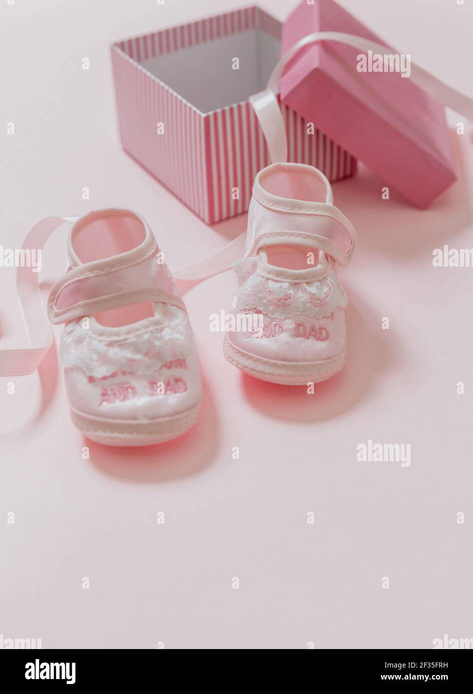 Babydusche, Mädchen Taufe Konzept. Baby rosa Schuhe auf rosa Farbe Hintergrund. Es ist ein Mädchen neugeboren Ankündigung. Weiche Frauenschuhe für Kleinkinder aus Stockfoto