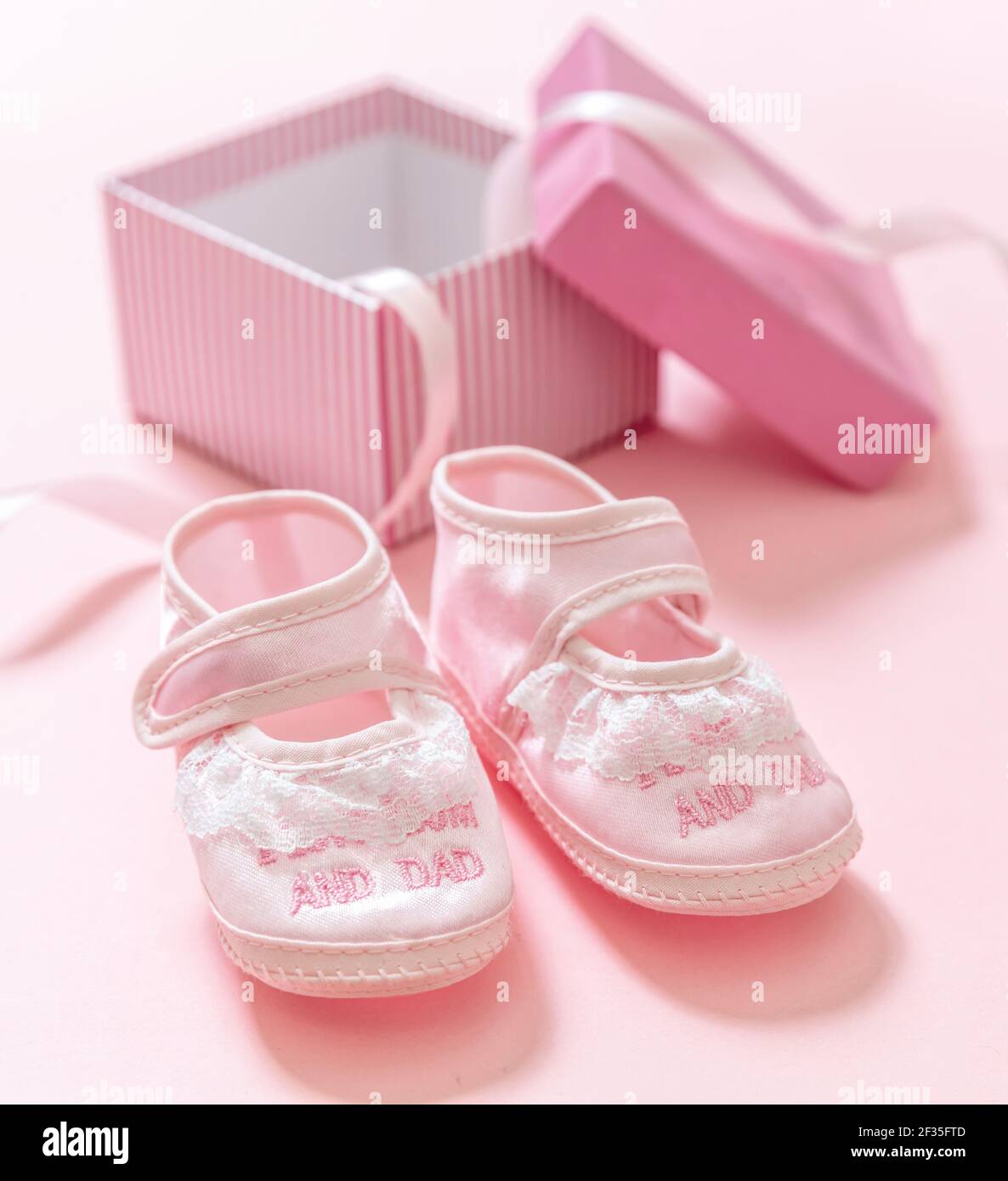 Babydusche, Mädchen Taufe Konzept. Baby rosa Schuhe auf rosa Farbe Hintergrund. Es ist ein Mädchen neugeboren Ankündigung. Weiche Frauenschuhe für Kleinkinder aus Stockfoto