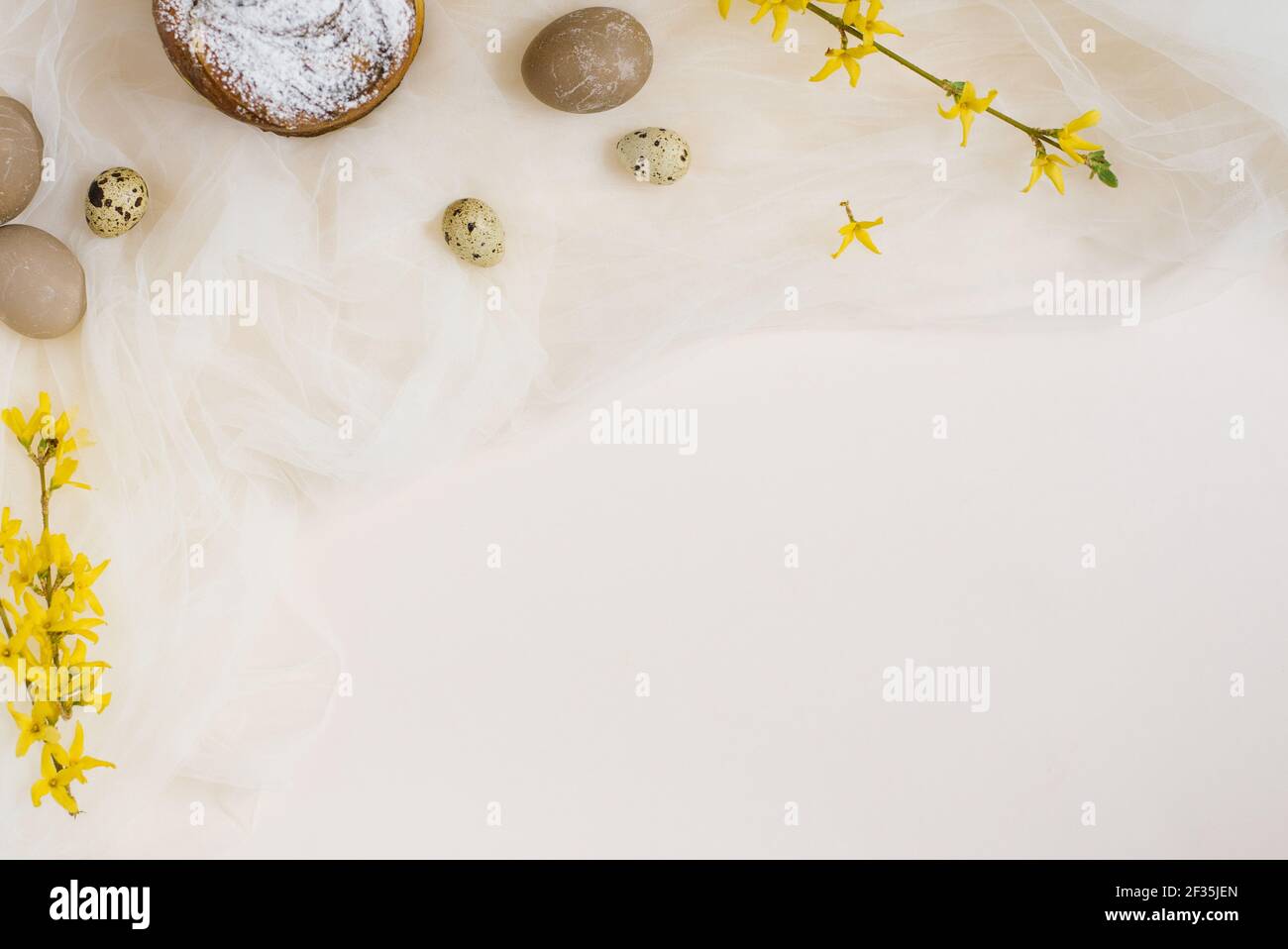 Osterkuchen, Eier, Forsythia Zweige auf beigem Hintergrund. Platz kopieren, flach liegend. Osterkonzept Stockfoto