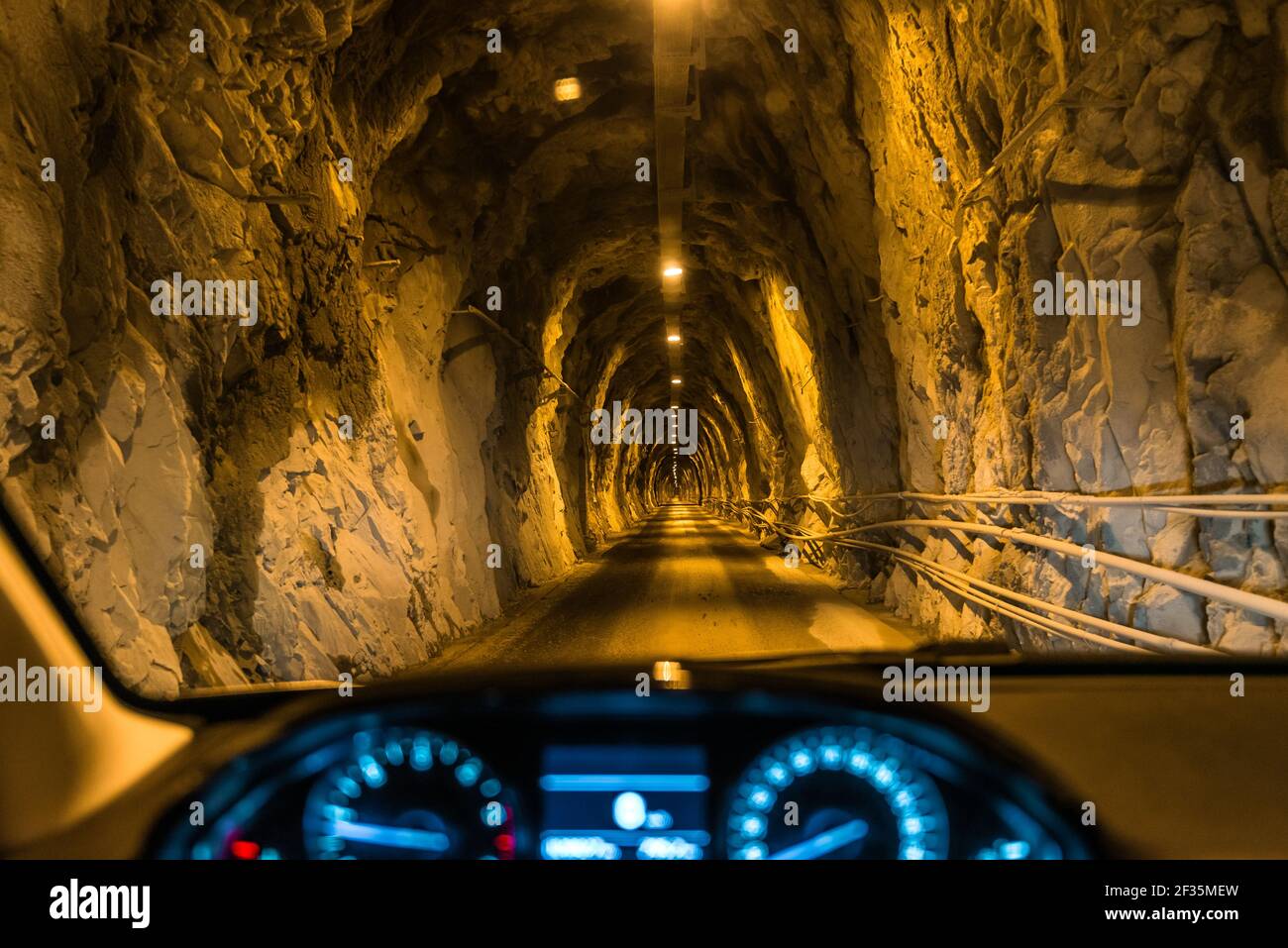 Fahrt durch einen engen Straßentunnel, der aus Sicht des Fahrers in das Felsmassiv ausgegraben wurde. Individueller Personentransport. Stockfoto