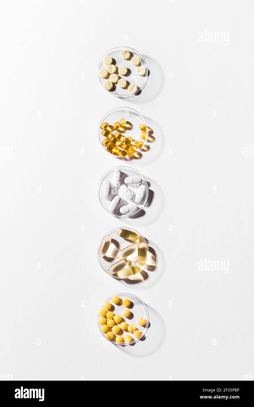 Vitamine Kapseln auf weißem Hintergrund, Draufsicht, Kopierraum. Nahrungsergänzungsmittel: Fischöl, Omega 3, Omega 6, Omega 9, Vitamin A, D3, E, B, KALZIUM. Stockfoto