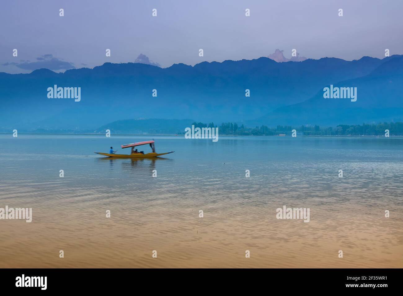 Spiegelung der Himalaya-Berge am Dal Lake, Srinagar, Jammu und Kaschmir, Indien. Hausboote schwimmen am späten Nachmittag auf dem See. Stockfoto
