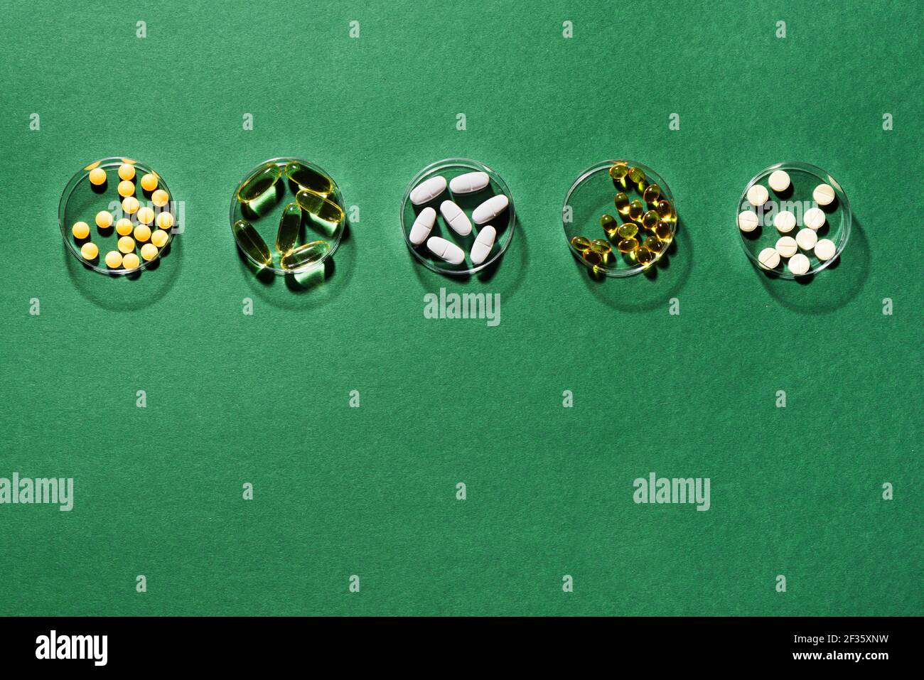 Vitamine Medizin Kapseln auf grünem Hintergrund, Draufsicht, Kopierraum. Nahrungsergänzungsmittel: Fischöl, Omega 3, Omega 6, Omega 9, Vitamin A, D3, E, B, KAL Stockfoto
