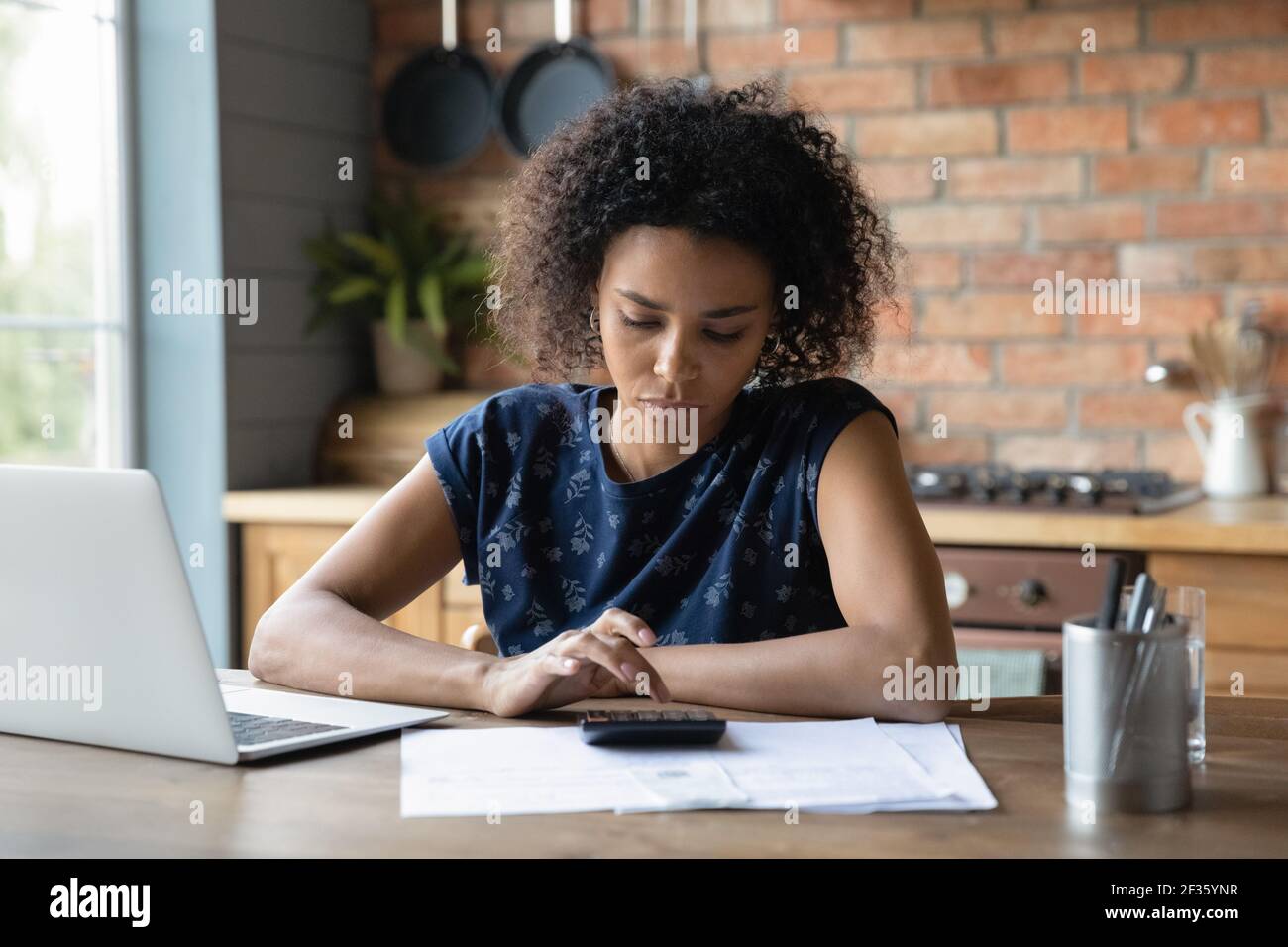 Nachdenklich junge schwarze Frau zählen Steuersatz vor Online bezahlen Stockfoto