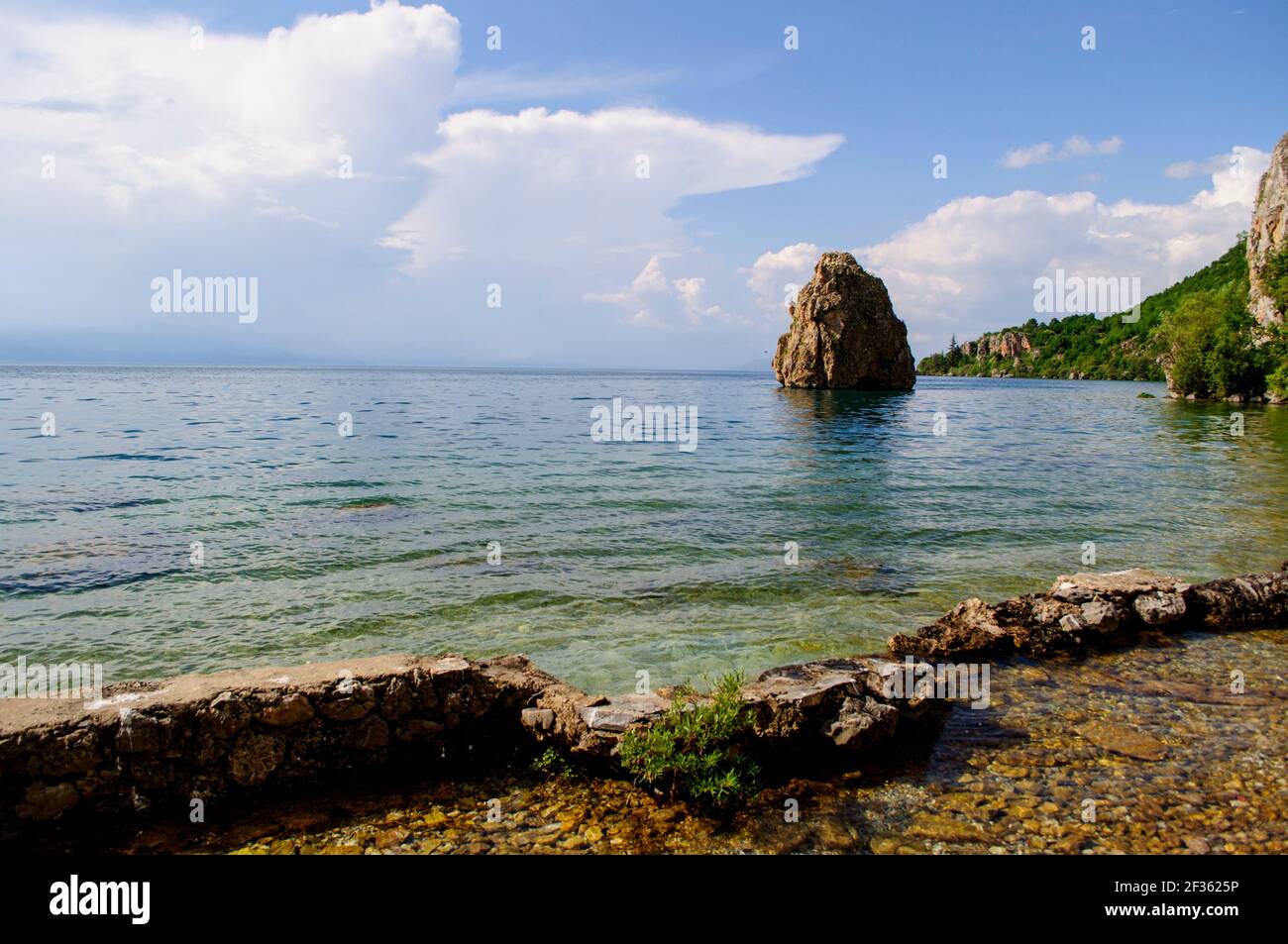 Großer Felsen, umgeben von Wasser am Ufer eines Sees. Stockfoto