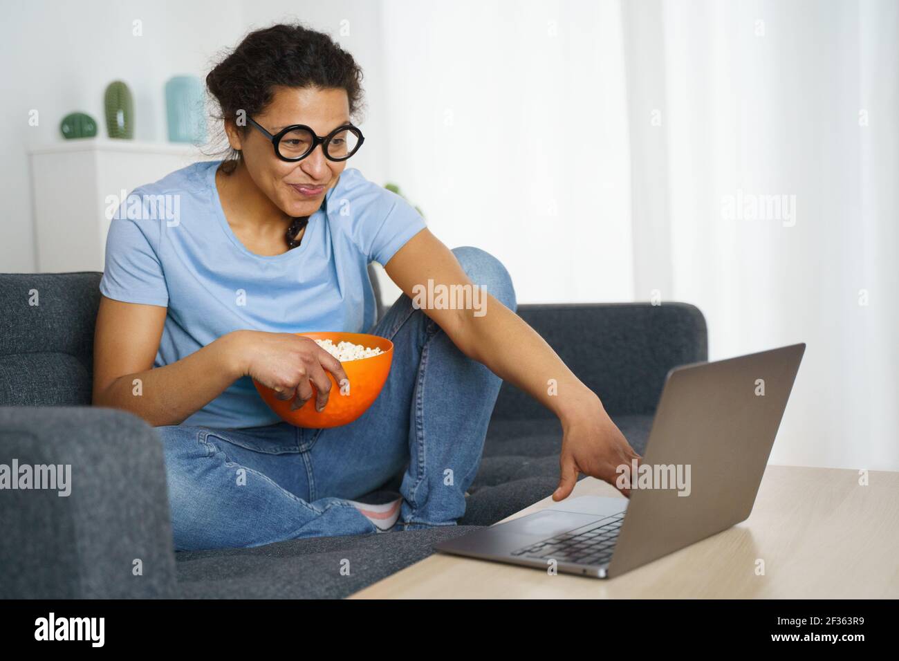 Fröhliche afroamerikanische Frau beim Streaming von netflix Stockfoto