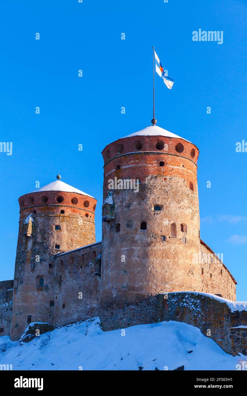 Vertikales Foto der Olavinlinna unter blauem Himmel an einem sonnigen Wintertag. Es ist ein dreitürmtes Schloss aus dem 15th. Jahrhundert. Savonlinna, Finnland. Die Festung war Stockfoto