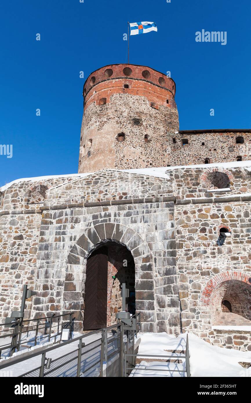 Vertikales Foto des Olavinlinna Eingangs unter blauem Himmel an einem sonnigen Wintertag. Es ist ein dreitürmtes Schloss aus dem 15th. Jahrhundert. Savonlinna, Finnland. Die für Stockfoto