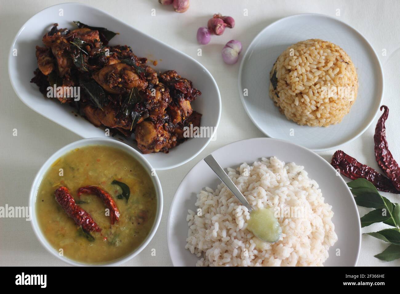 Einfache Kerala-Stil Hähnchenmahlzeiten mit Parboiled Reis und Linsen Curry. Huhn wird mit 5 Zutaten zubereitet. Aufnahme auf weißem Hintergrund Stockfoto