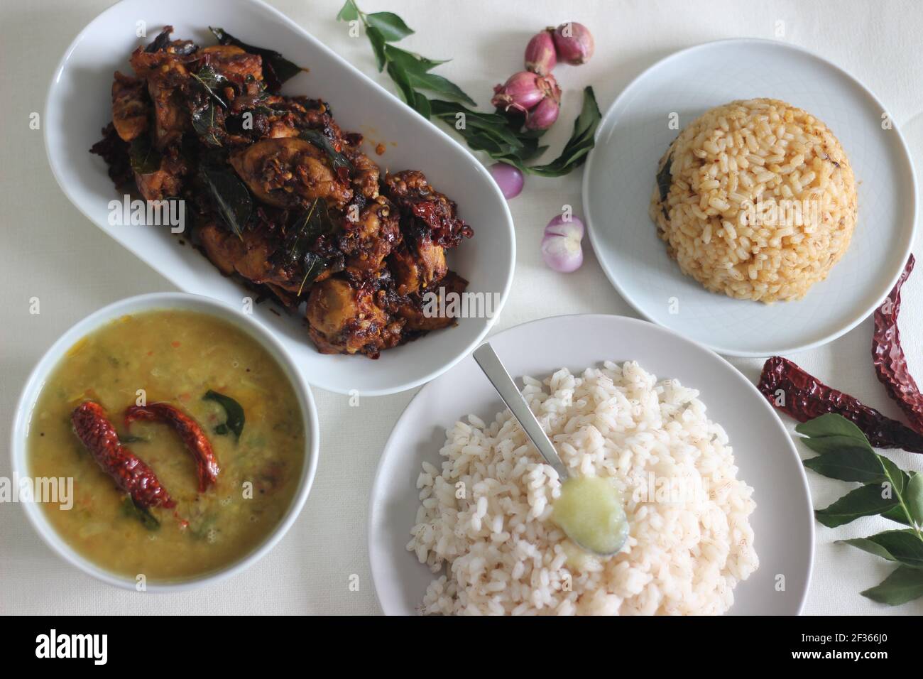 Einfache Kerala-Stil Hähnchenmahlzeiten mit Parboiled Reis und Linsen Curry. Huhn wird mit 5 Zutaten zubereitet. Aufnahme auf weißem Hintergrund Stockfoto