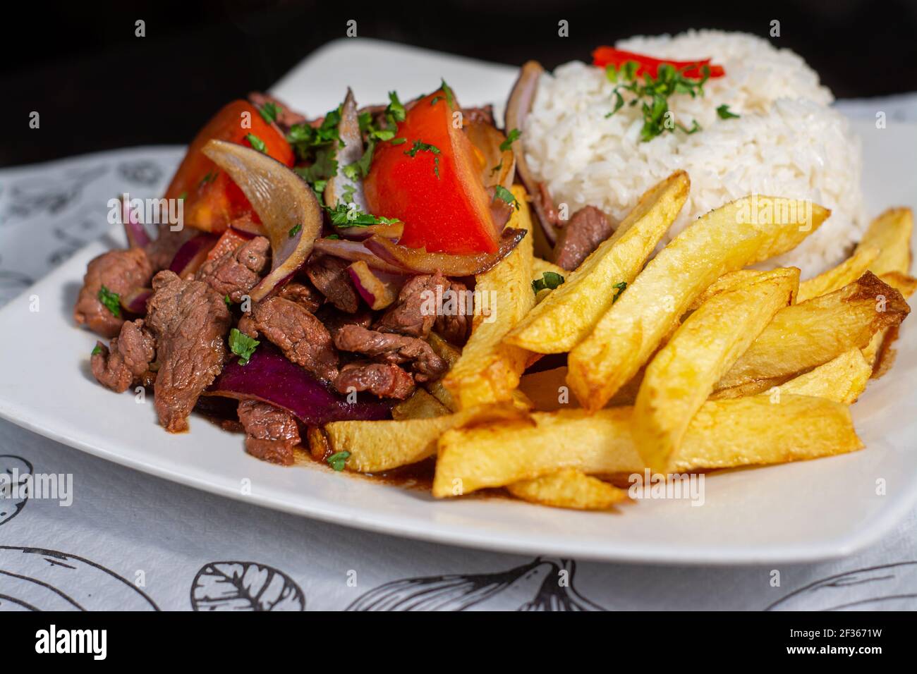 Peruanische traditionelle Küche. Ein Rindfleisch mit Tomaten, Zwiebeln, Reis und gebratenen Kartoffeln, Lomo saltado Stockfoto