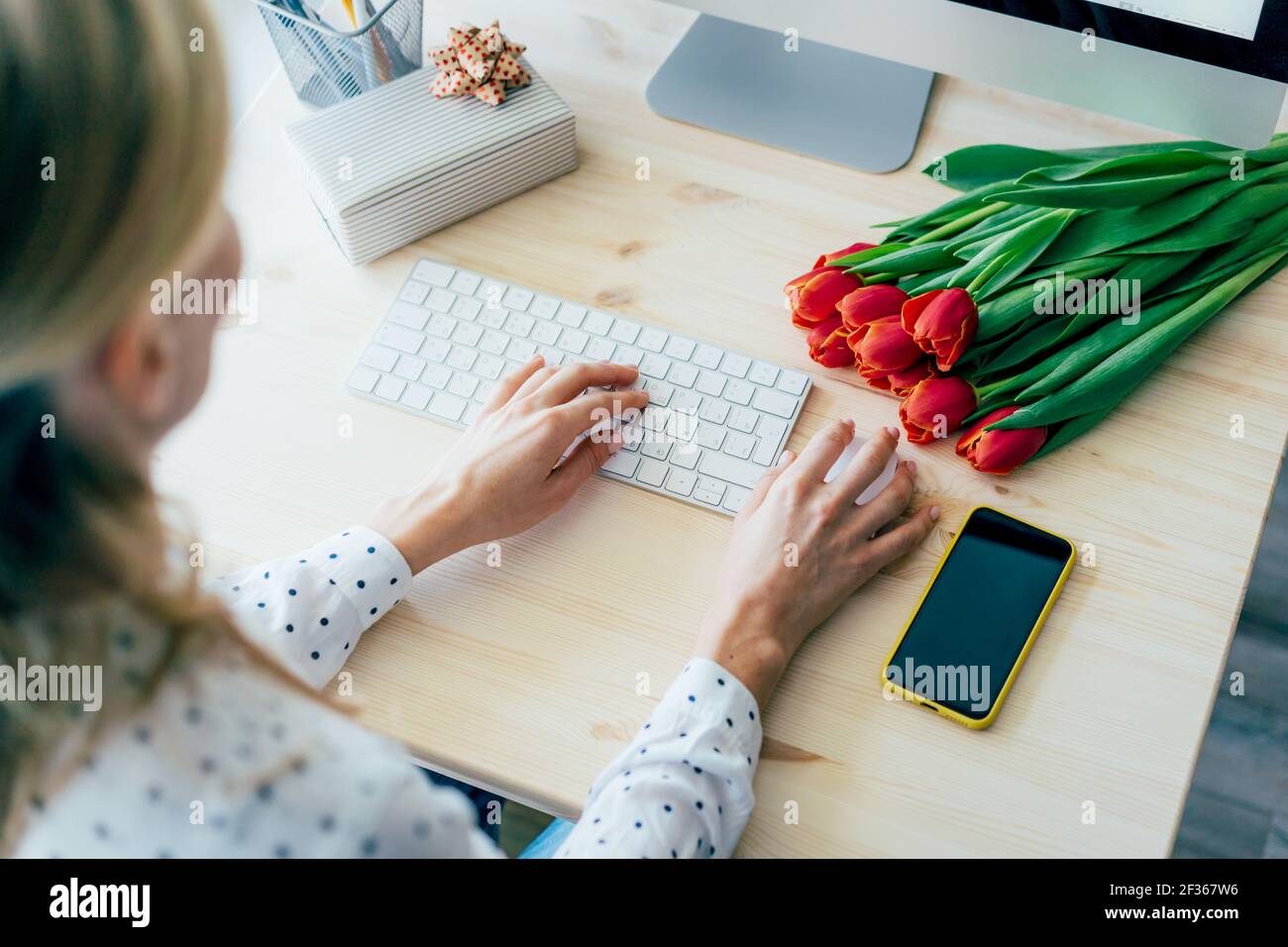 Eine Frau tippt auf einer Computertastatur. Geschäftsfrau. Unabhängige selbstbewusste arbeitende Dame. Stockfoto