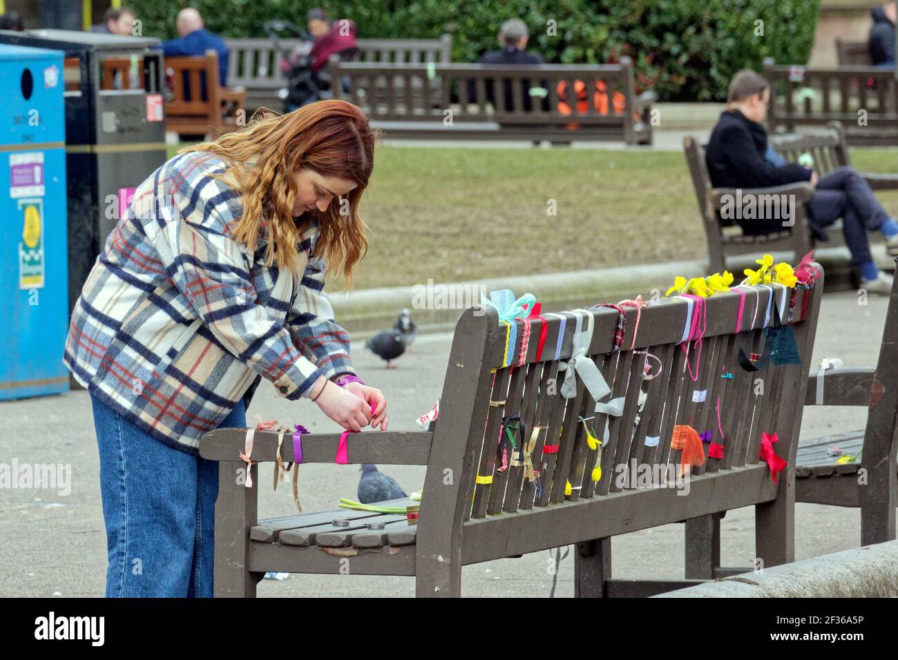 Glasgow, Schottland, Großbritannien 15th. März 2021. Sarah Everard Tributes sah die Bänke auf dem George Square, dem Herzen des Stadtzentrums, und schmückte sie mit Blumen und Bändern, während Slogans ihre Botschaft vorlegten. Eine Vielzahl von Menschen stoppten und lesen oder zu den Ehrungen hinzugefügt.. Quelle: Gerard Ferry/Alamy Live News Stockfoto