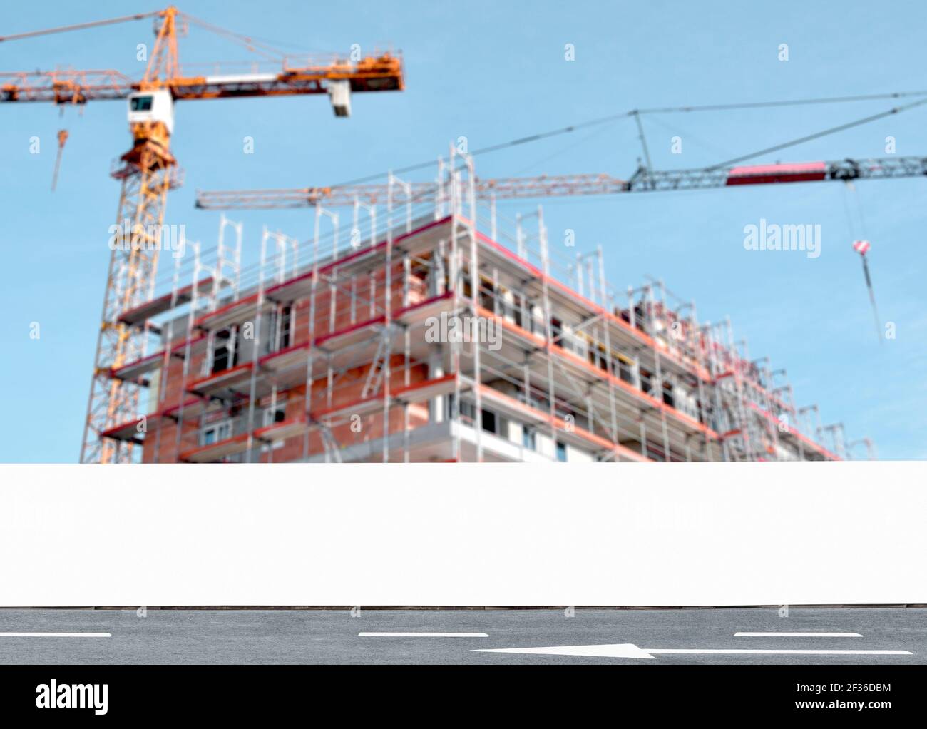 Weißer blank Bauzaun mit Baustelle im Hintergrund, Hording Panel mit Kopierraum für Branding oder Entwicklung Projekt Informationen Stockfoto