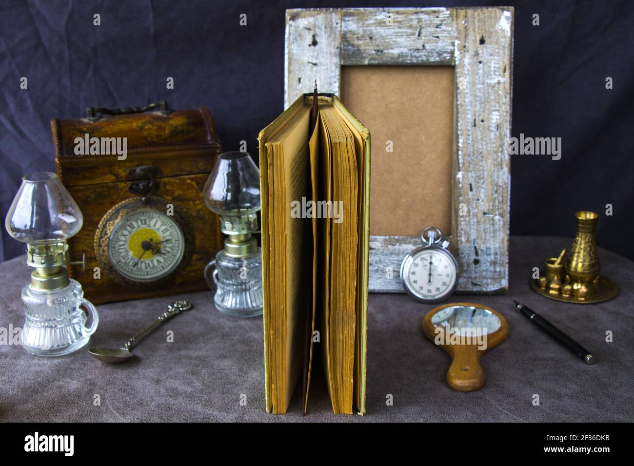 Die Vintage-Objekte auf dem Tisch, alte Box, Lampe, Uhr, Buch, Stift und andere Dinge Stockfoto