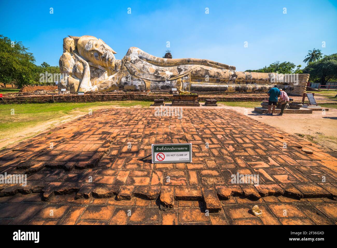 Lotusblumen unterstützen den Kopf des sich rückenden Buddha im Wat Lokaya Sutha, Phra Nakorn Sri Ayutthaya, Thailand. UNESCO-Weltkulturerbe. Stockfoto