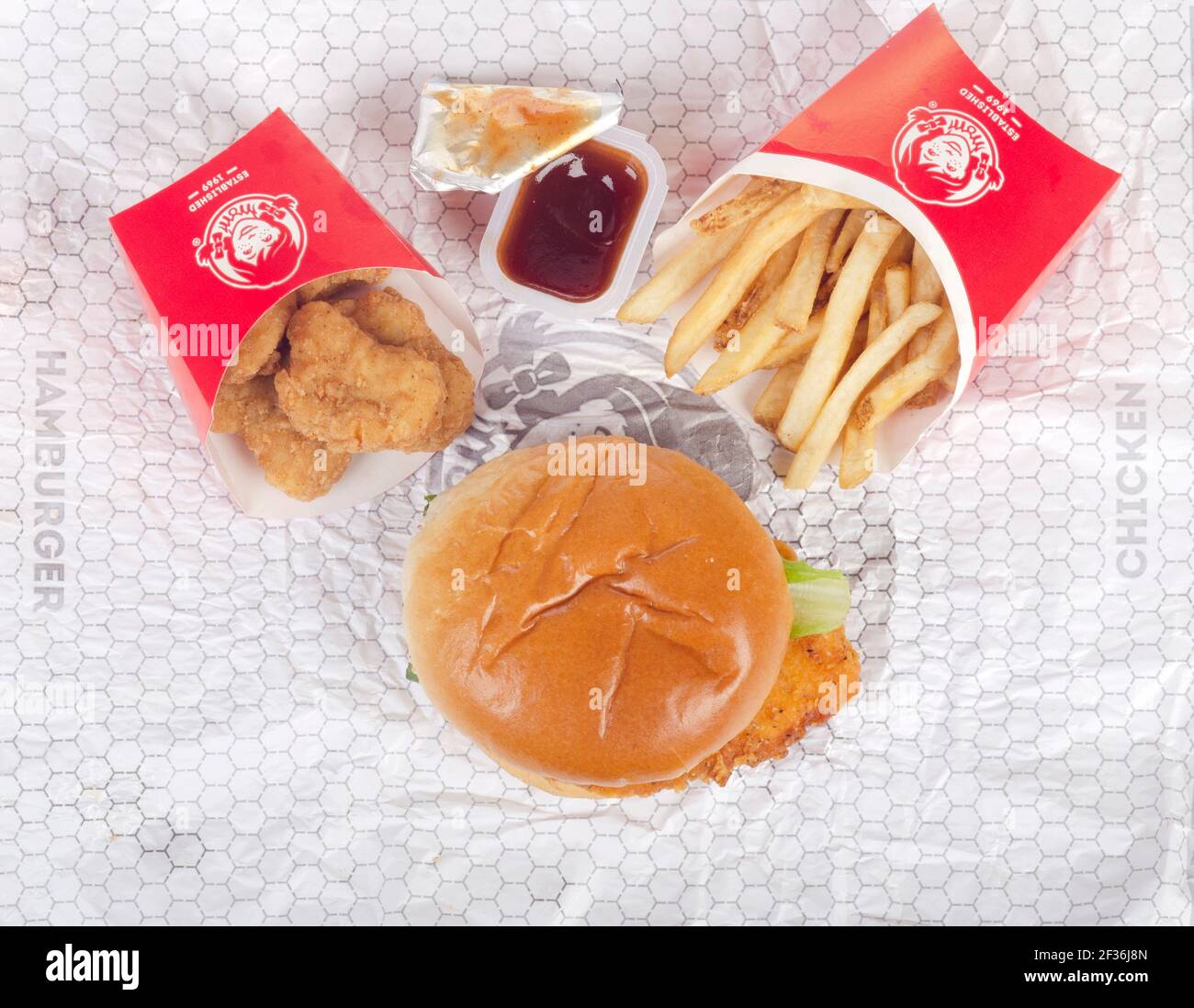 Wendy's Spicy Chicken Sandwich auf Wrapper mit Chicken Nuggets, BBQ Dipping Sauce & French Fries aka Chips Stockfoto