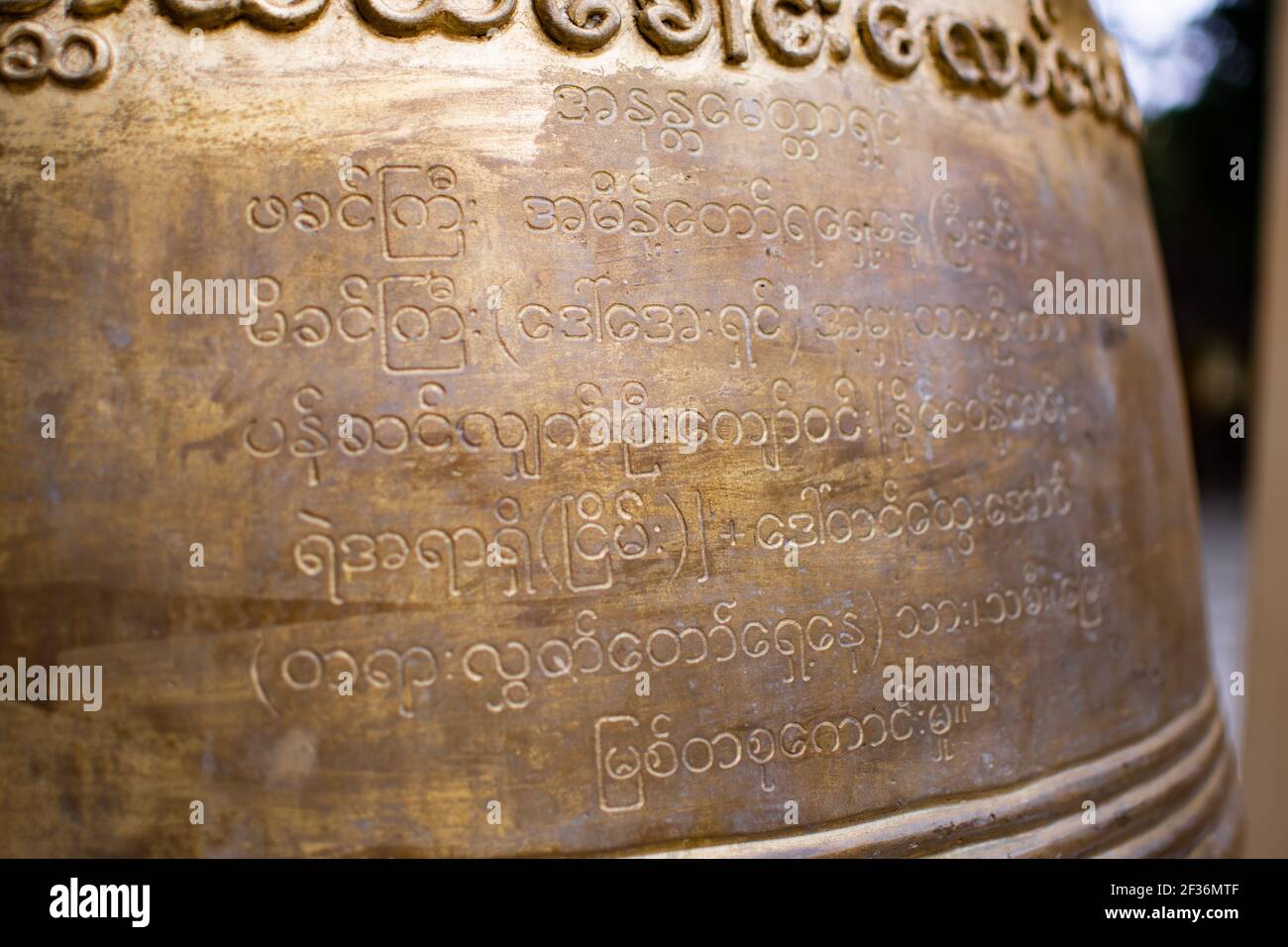 BAGAN, NYAUNG-U, MYANMAR - 2. JANUAR 2020: Nahaufnahme eines burmesischen Textes auf einer großen massiven buddhistischen Glocke durch einen historischen Pagodentempel Stockfoto