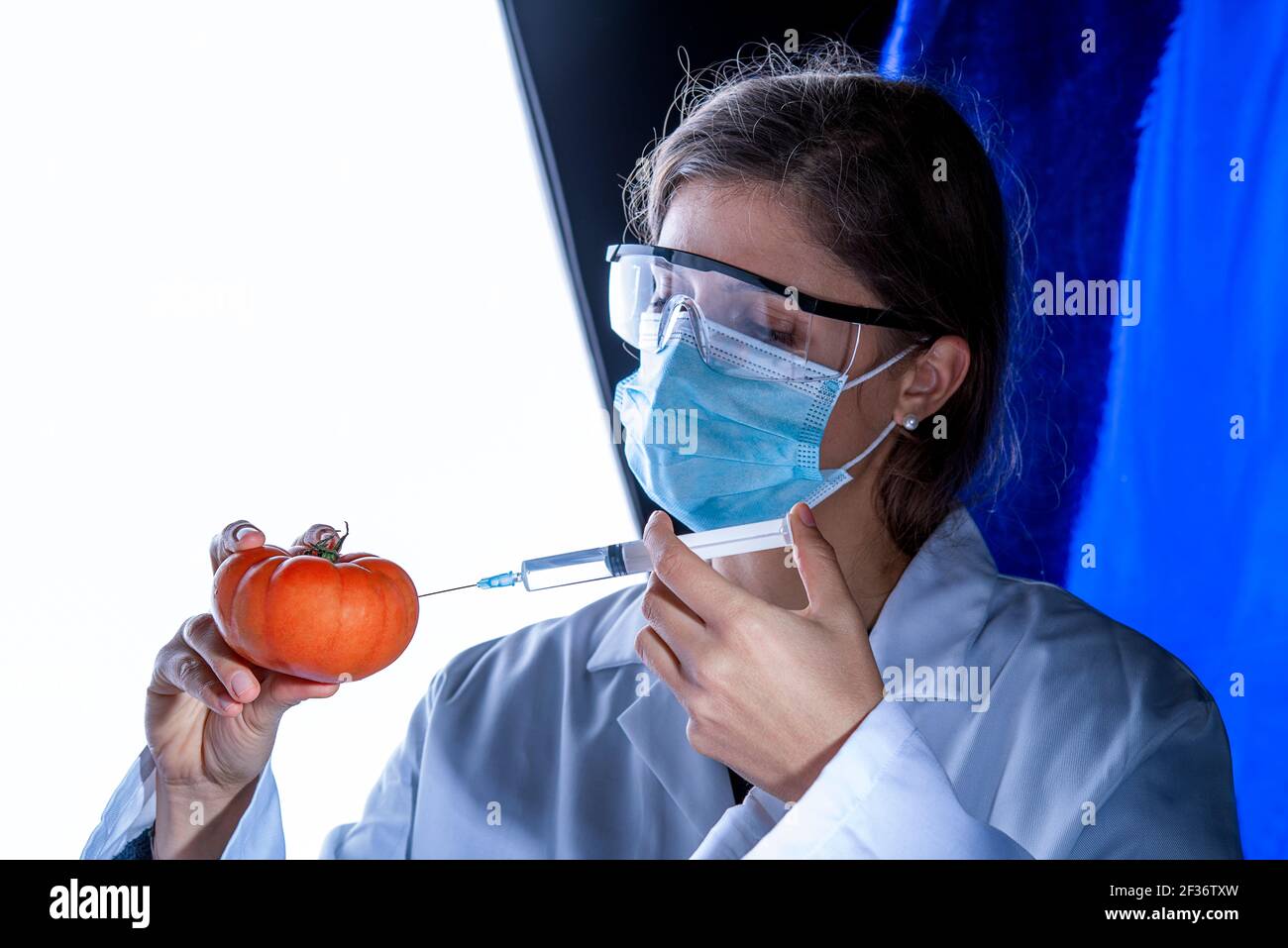 Lebensmittelqualitätskontrollkonzept Tomate mit einer Spritze analysieren Stockfoto