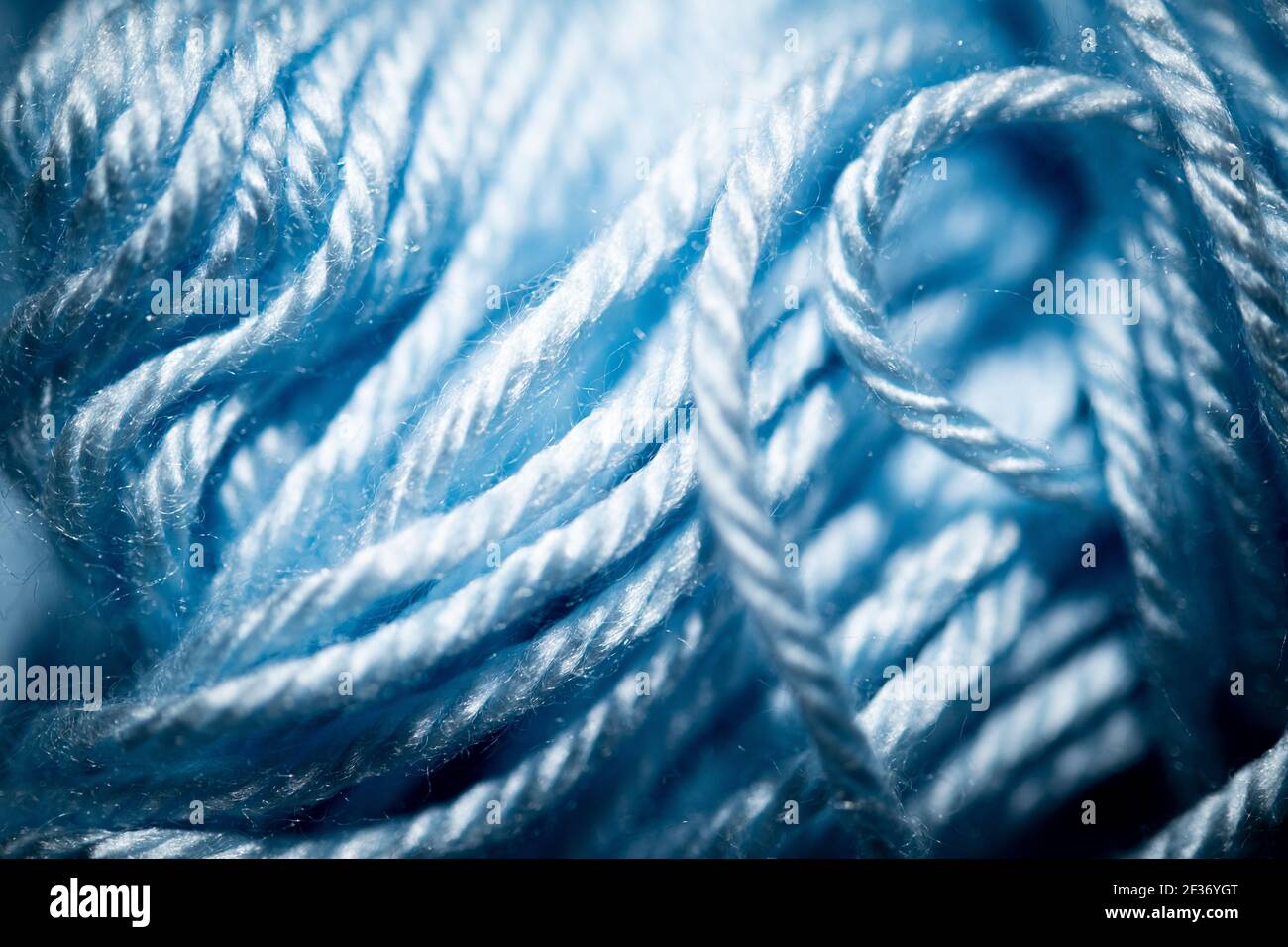 Eine extreme Nahaufnahme mit selektivem Fokus von blauen und fuzzy gebündelten Häkelfäden. Stockfoto