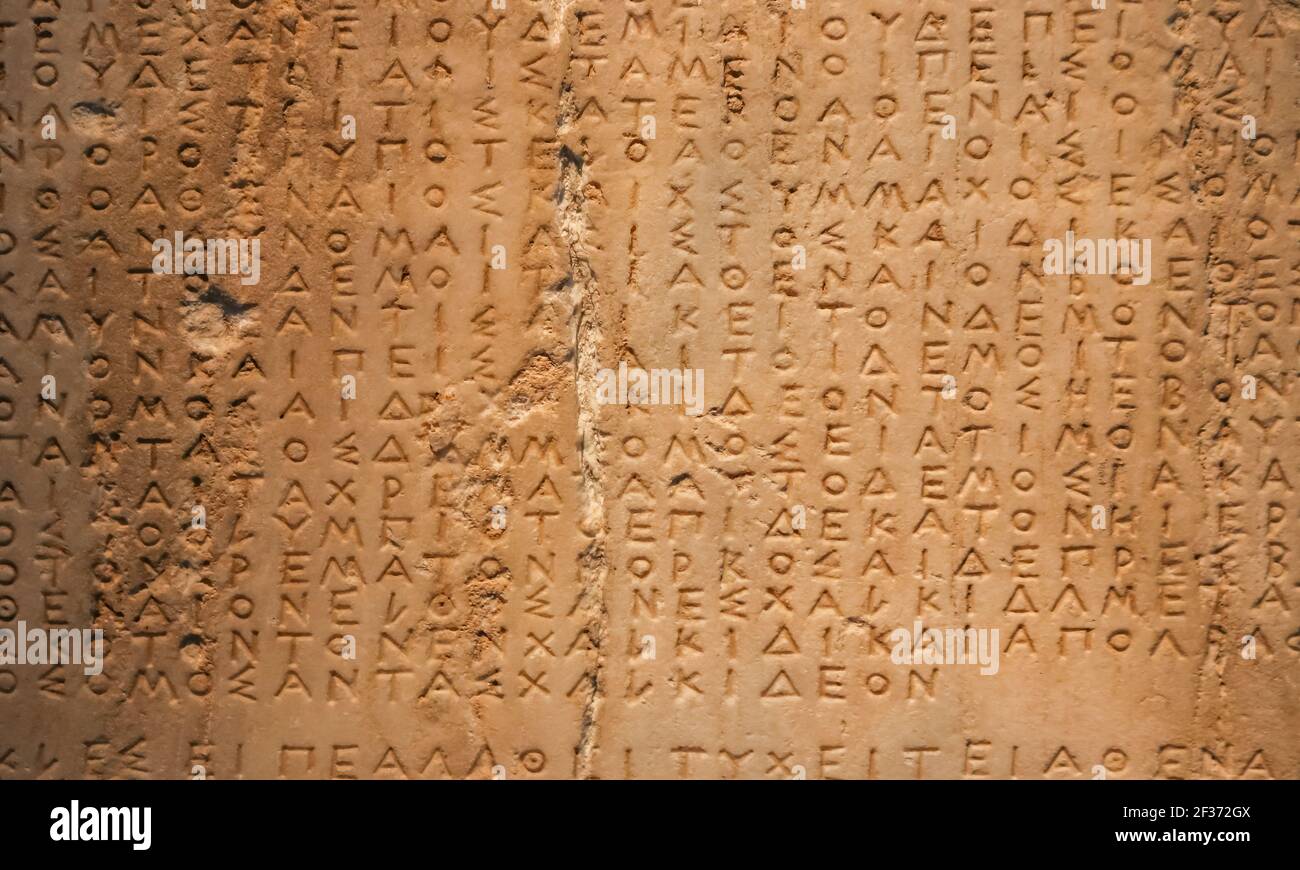 Artefakt mit griechischer Schrift in ein Stück Stein gemeißelt Mit einem vertikalen Riss durch ihn p - Hintergrund Stockfoto