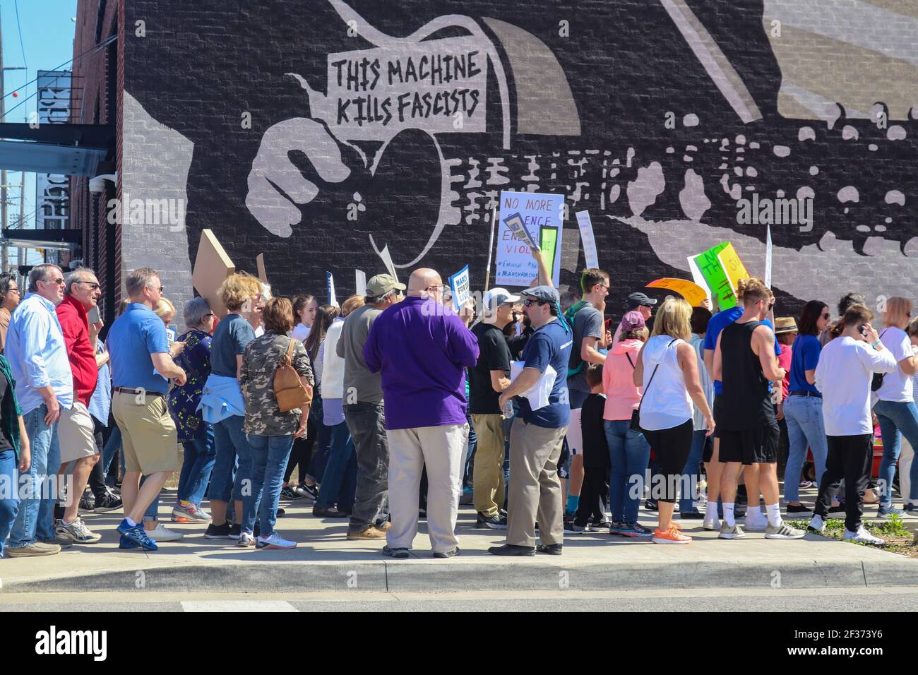 3 24 2018 Tulsa Oklahom USA - Protestler gehen vorbei Holz Guthrie Wandbild, das sagt, Diese Maschine tötet Faschisten Stockfoto