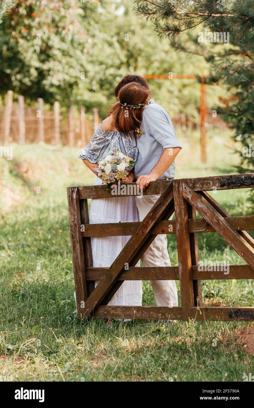 Eklektisches rustikales Hochzeitspaar. Intime Zeremonie im Hinterhof Stockfoto