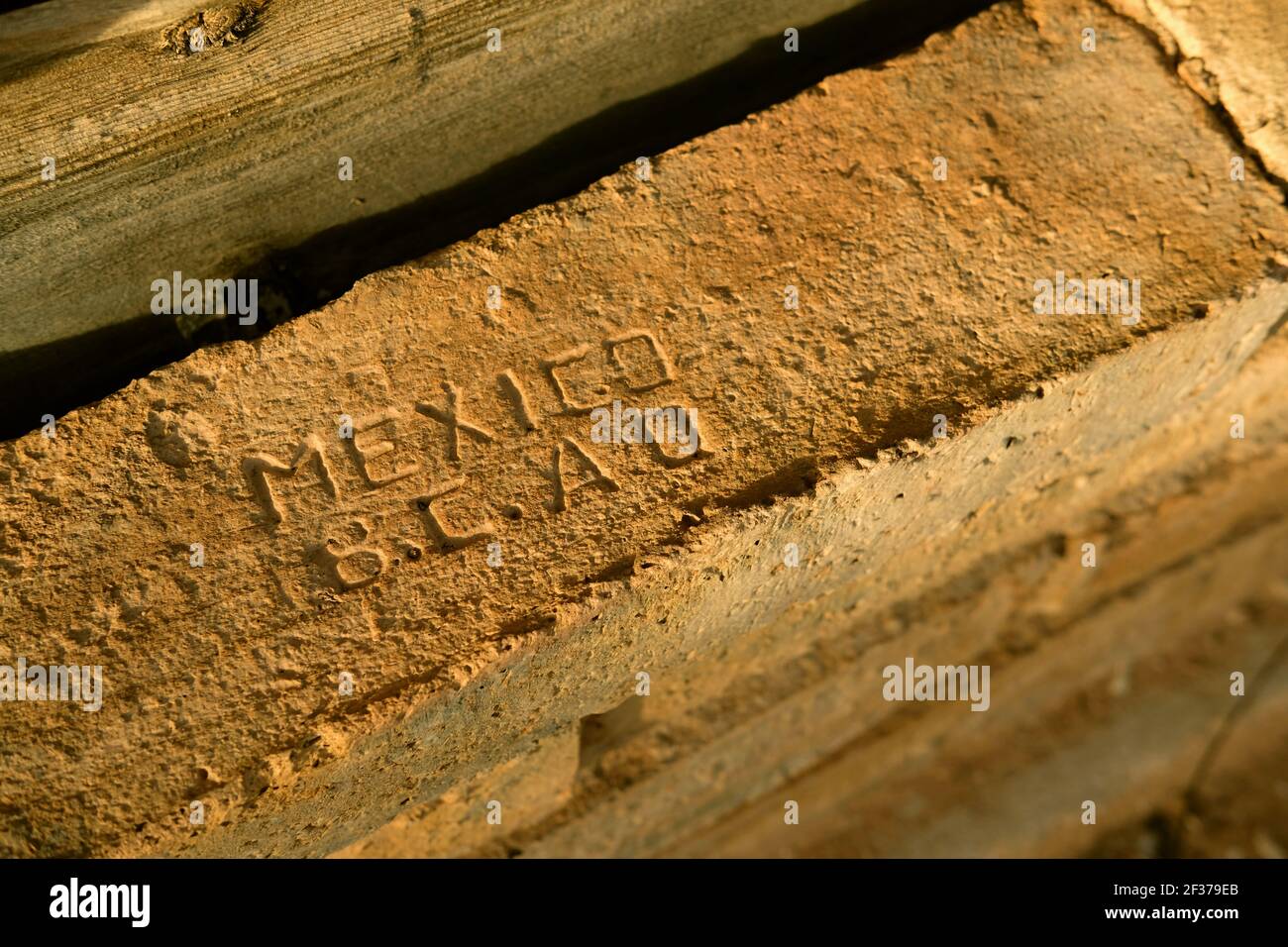 Freiliegender Ziegel mit IN MEXIKO gebackenem; an der Basis eines verfallenen alten Gebäudes; hergestellt in Mexiko; gefunden in einem verlassenen Fundament in der Arizona Wüste. Stockfoto