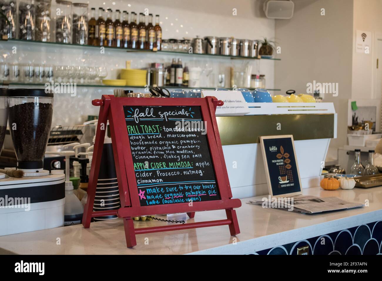 Café Café-Café-Schild, bunte Kreide auf einer Tafel mit roten Rahmen Auflistung Spezialitäten des Tages mit Kaffee-Artikel im Hintergrund Stockfoto