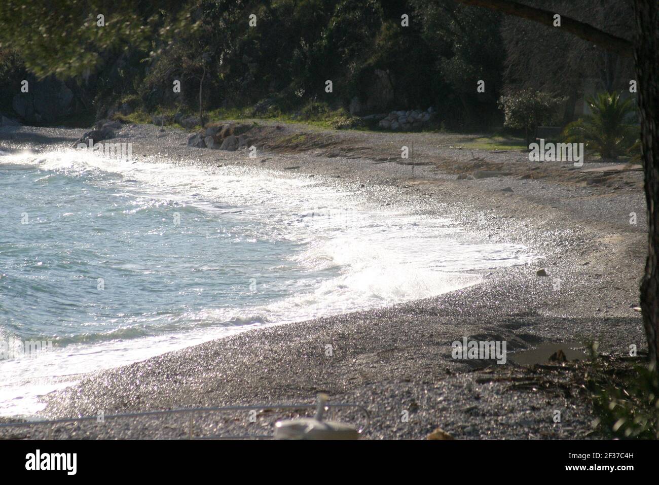 An einem windigen Tag im Winter brechen die Wellen an einem Kieselstrand Stockfoto