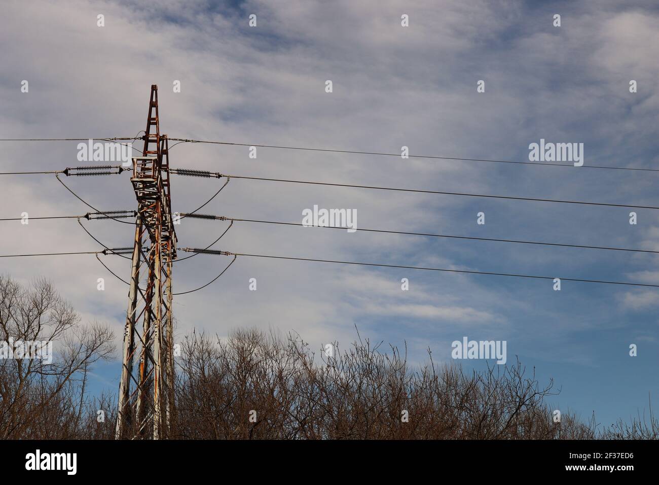 Elektrische Oberleitungen an einem Sendeturm gegen Weiß Und blauer Himmel Hintergrund Stockfoto