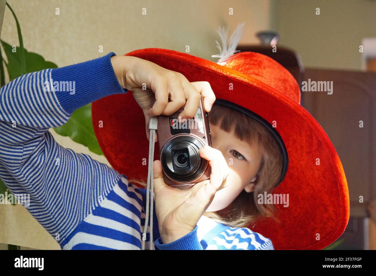 Braunhaariges Mädchen 5-10 Jahre alt in einem roten Maskenhut Mit einem Stockfoto