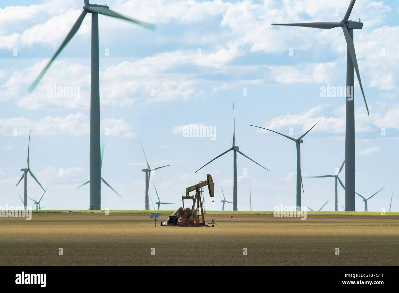 Solo Oil Derrick Steht Unter Modernen Windmühlen Stockfoto