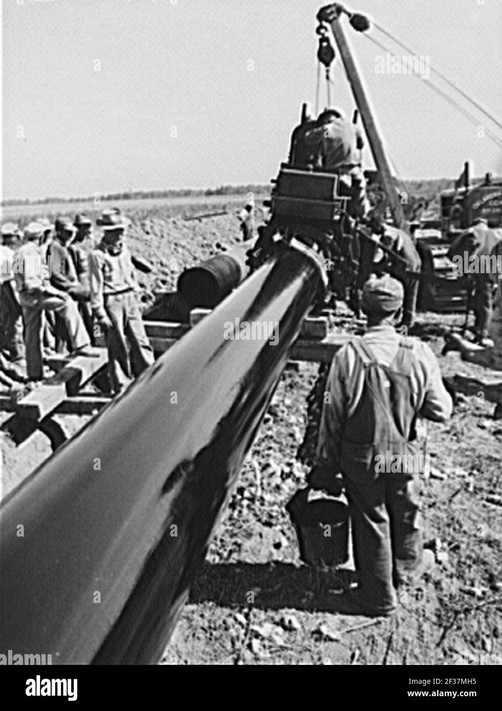 Grundierung Big Inch Rohr mit heißem Asphalt Farbe. Stockfoto