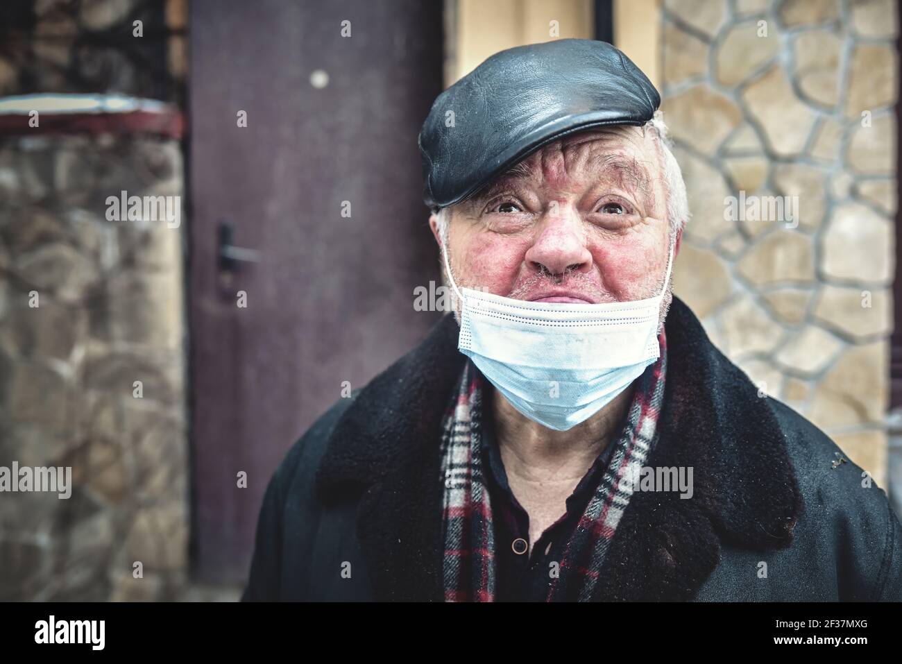 Kiew. Ukraine - Februar 4: 2021 die Schreie eines verletzten Obdachlosen, der eine Schutzmaske trägt, in eine Kamera schaut und sich in Quarantäne deprimiert fühlt Stockfoto