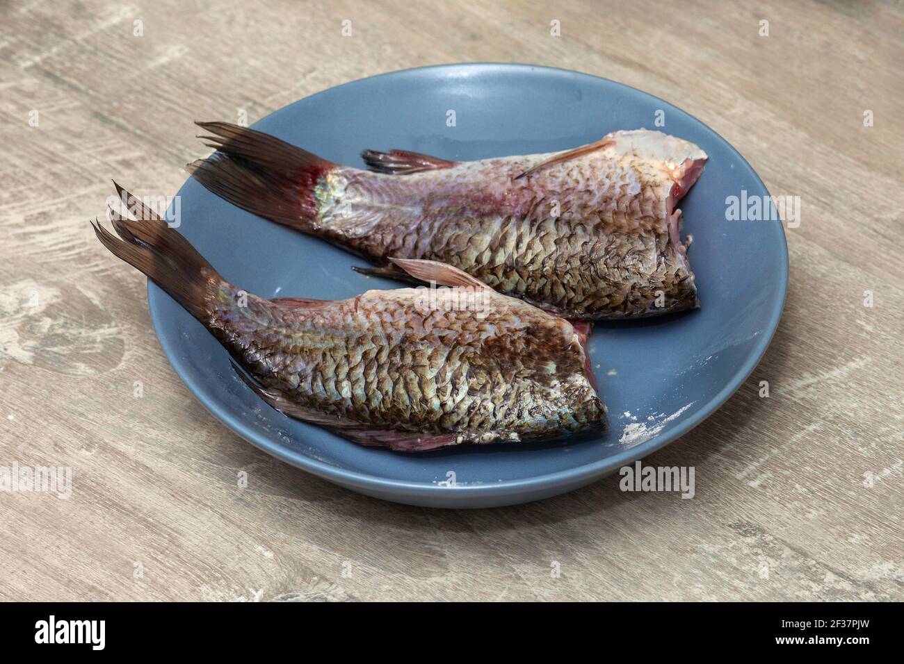 Frischer Karauschen-Karpfen-Fisch aus der Nähe auf einem Teller in der heimischen Küche. Fisch zum Braten geschält Stockfoto