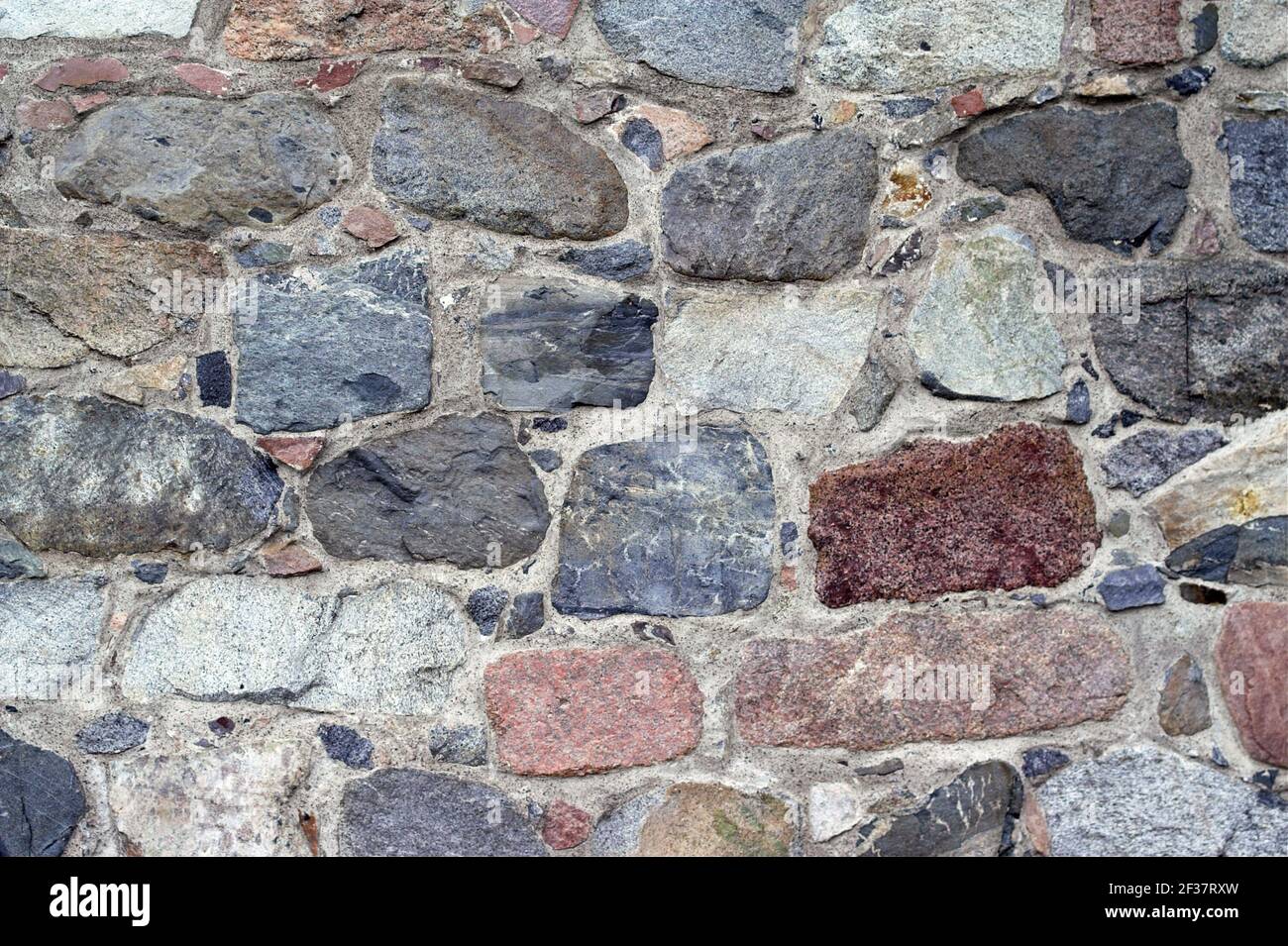 Gammelstad, Schweden, Schweden; EINE Wand aus großen, mehrfarbigen Steinen. Eine Wand aus großen, bunten Steinen. UN muro de grandes piedras de colores. Stockfoto