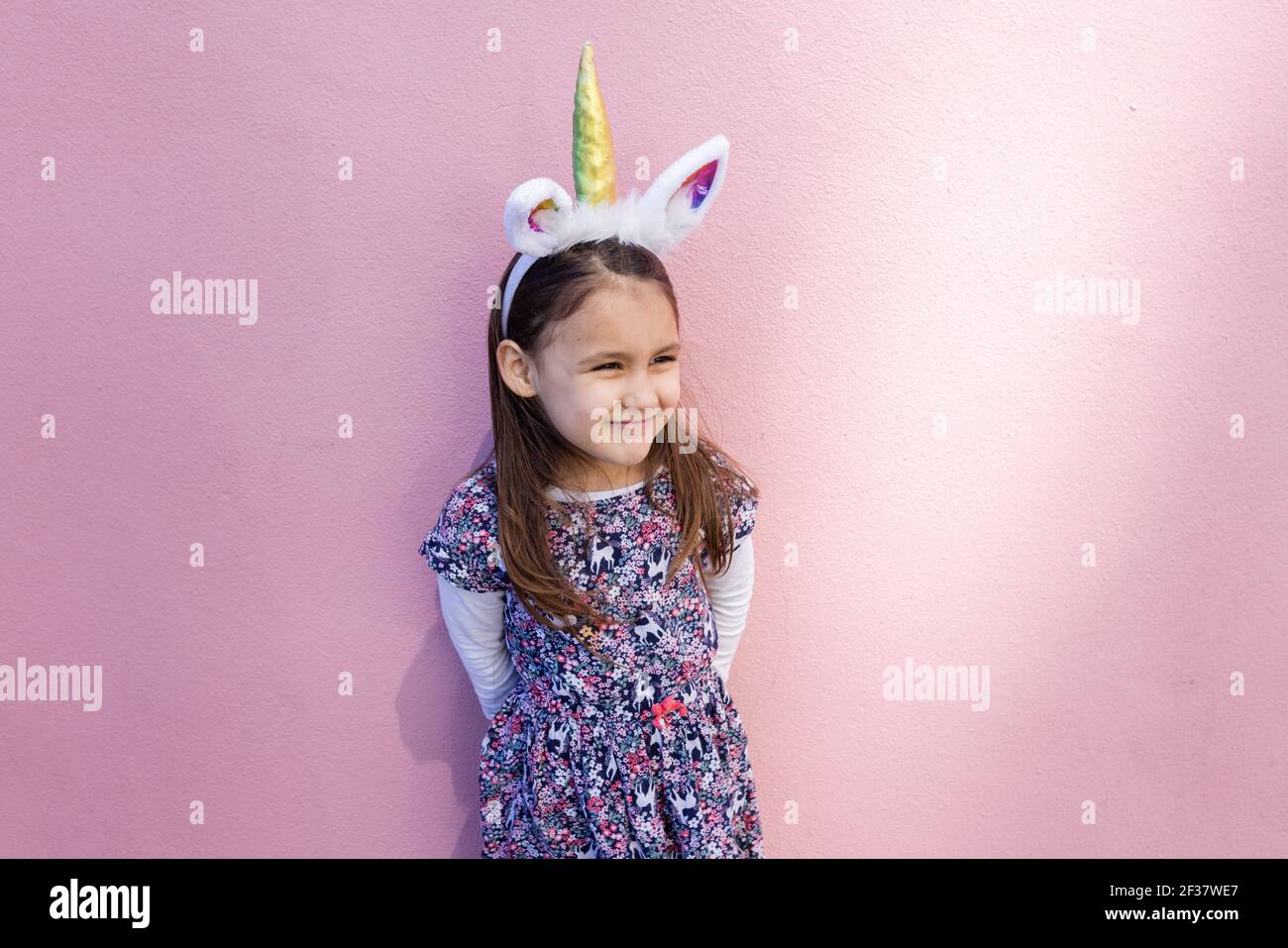 Liebenswert kleines Mädchen trägt ein Einhorn Stirnband mit rosa  Hintergrund Stockfotografie - Alamy