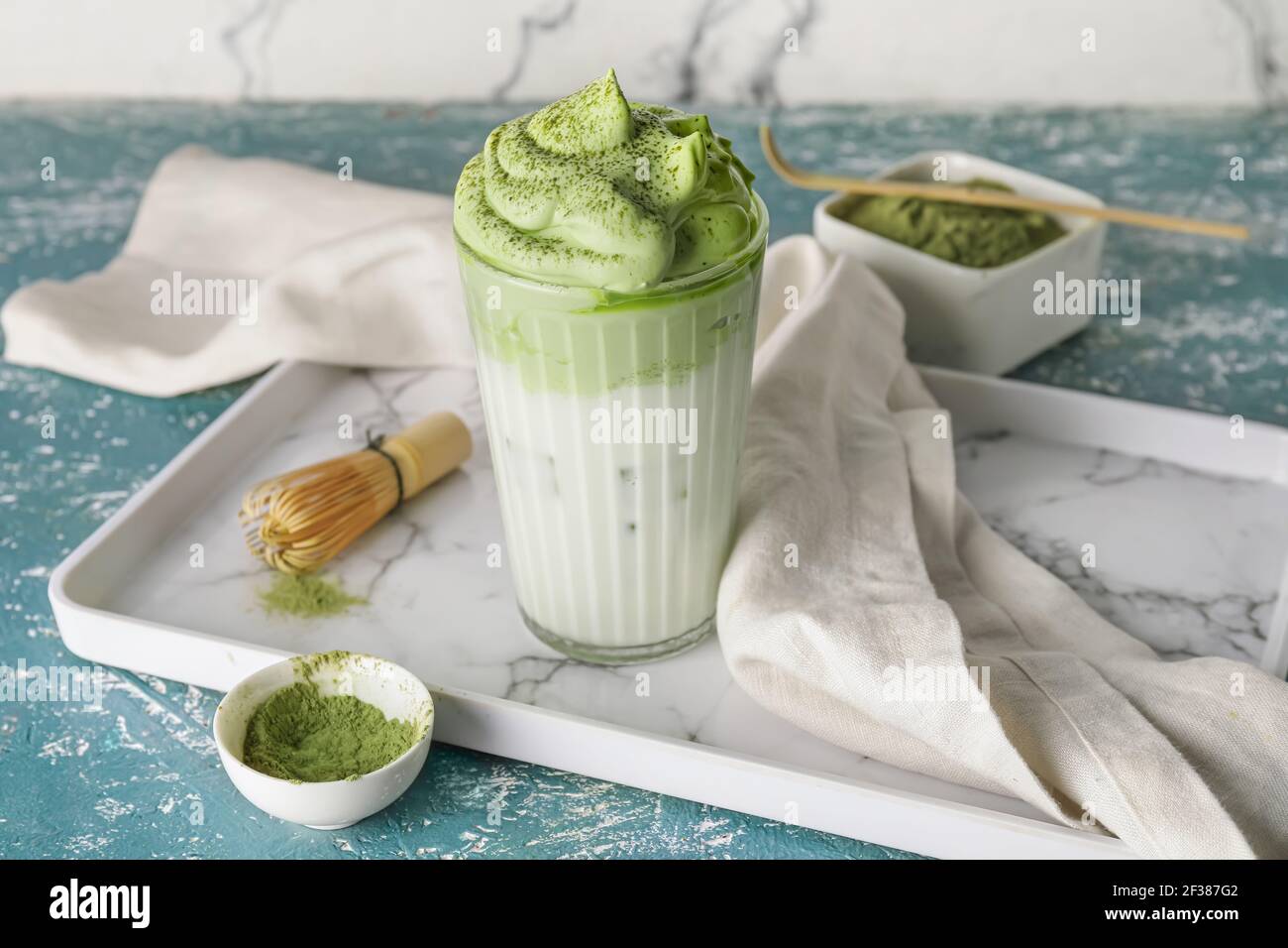 Komposition mit leckeren dalgona Matcha Latte auf farbigem Hintergrund Stockfoto