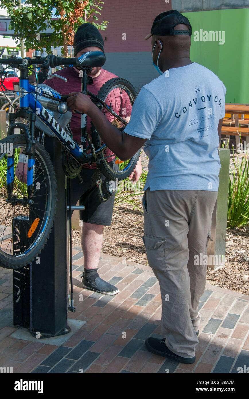 Diskussion im Gange an einer Fahrradreparaturstation auf dem Radweg unter der neu erhöhten Bahnlinie in der Nähe des Bahnhofs Murrumbeena, Melbourne, Australien Stockfoto