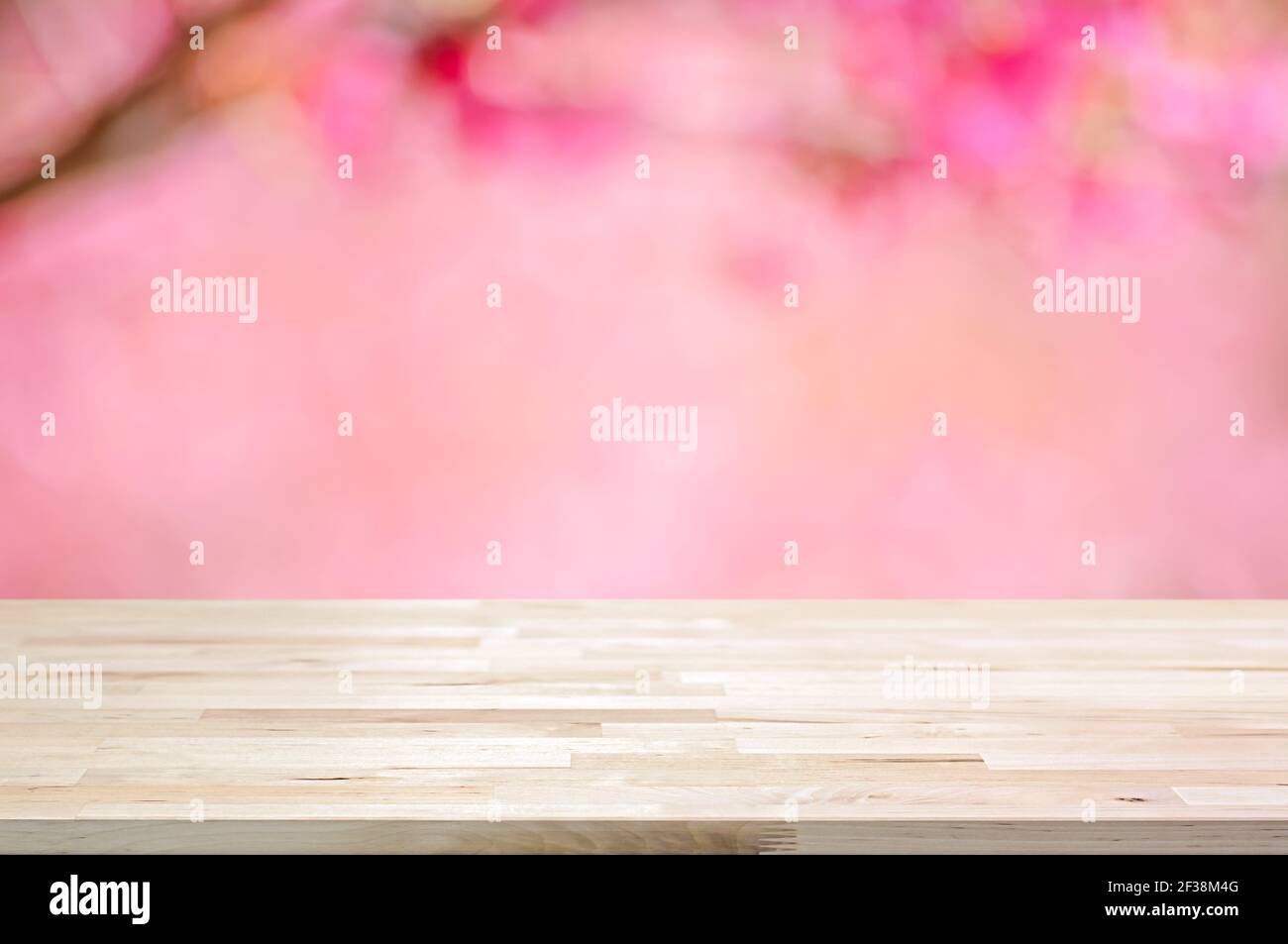 Holztischplatte auf verschwommenem Hintergrund von rosa Kirschblüte Blumen - kann für die Anzeige oder Montage Ihrer Produkte verwendet Stockfoto