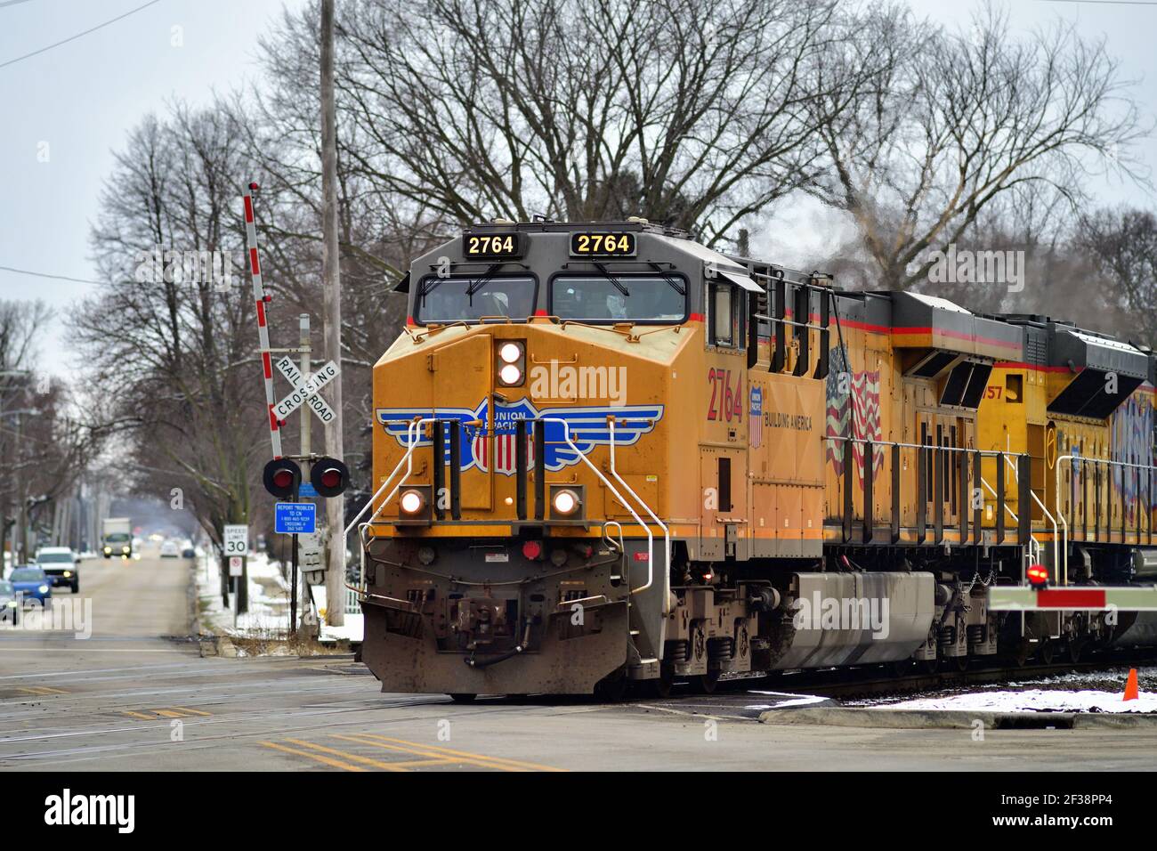West Chicago, Illinois, USA. Ein Güterzug der Union Pacific Railroad, der durch eine Straßenkreuzung fährt. Stockfoto