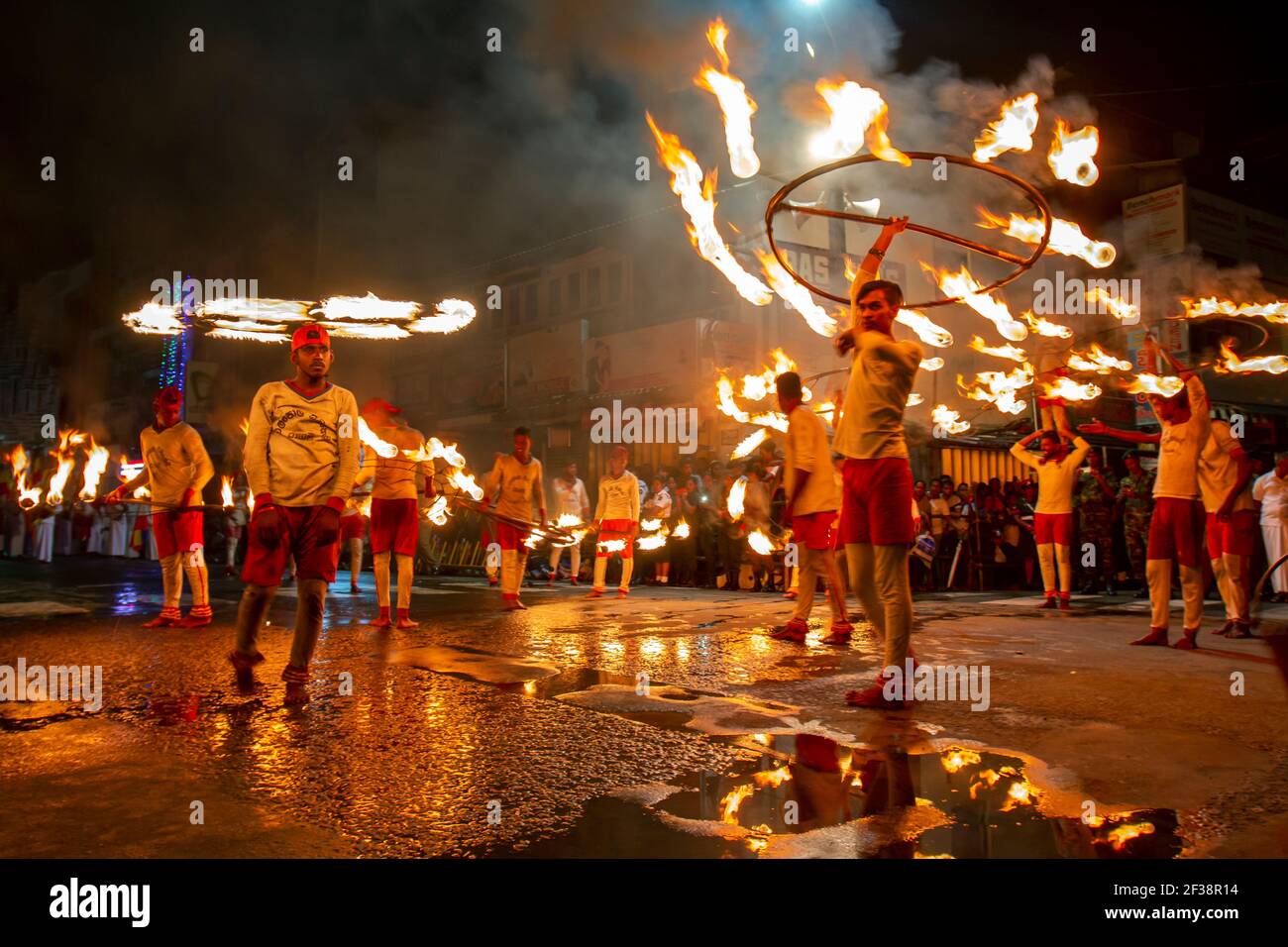 Feuerball-Tänzer führen entlang einer Straße während der buddhistischen Esala Perahera (große Prozession) in Kandy in Sri Lanka. Stockfoto