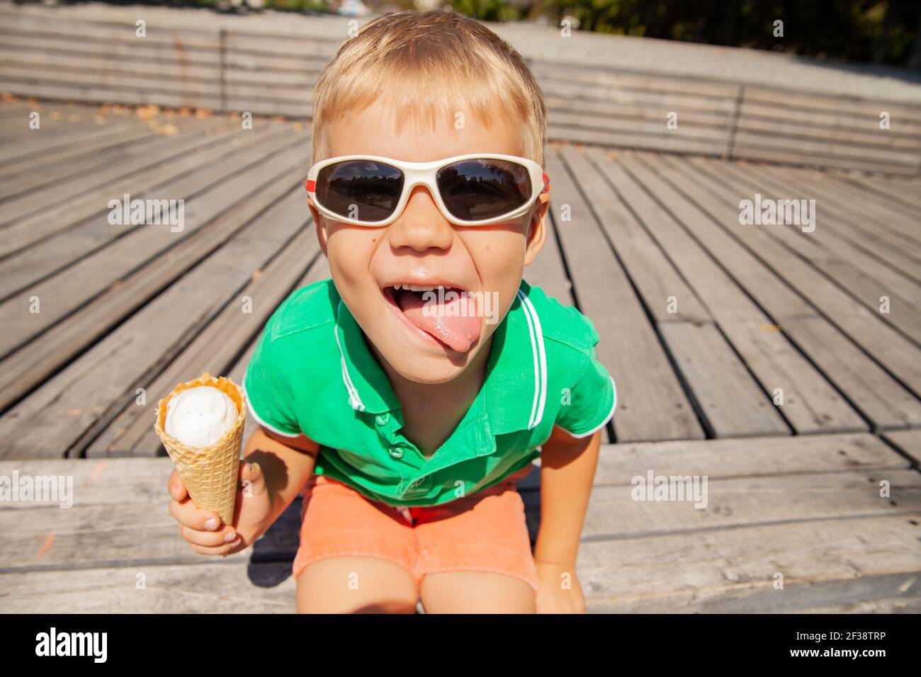 Verspielte Vorschulkinder mit Eiskegel mit Zunge Stockfoto