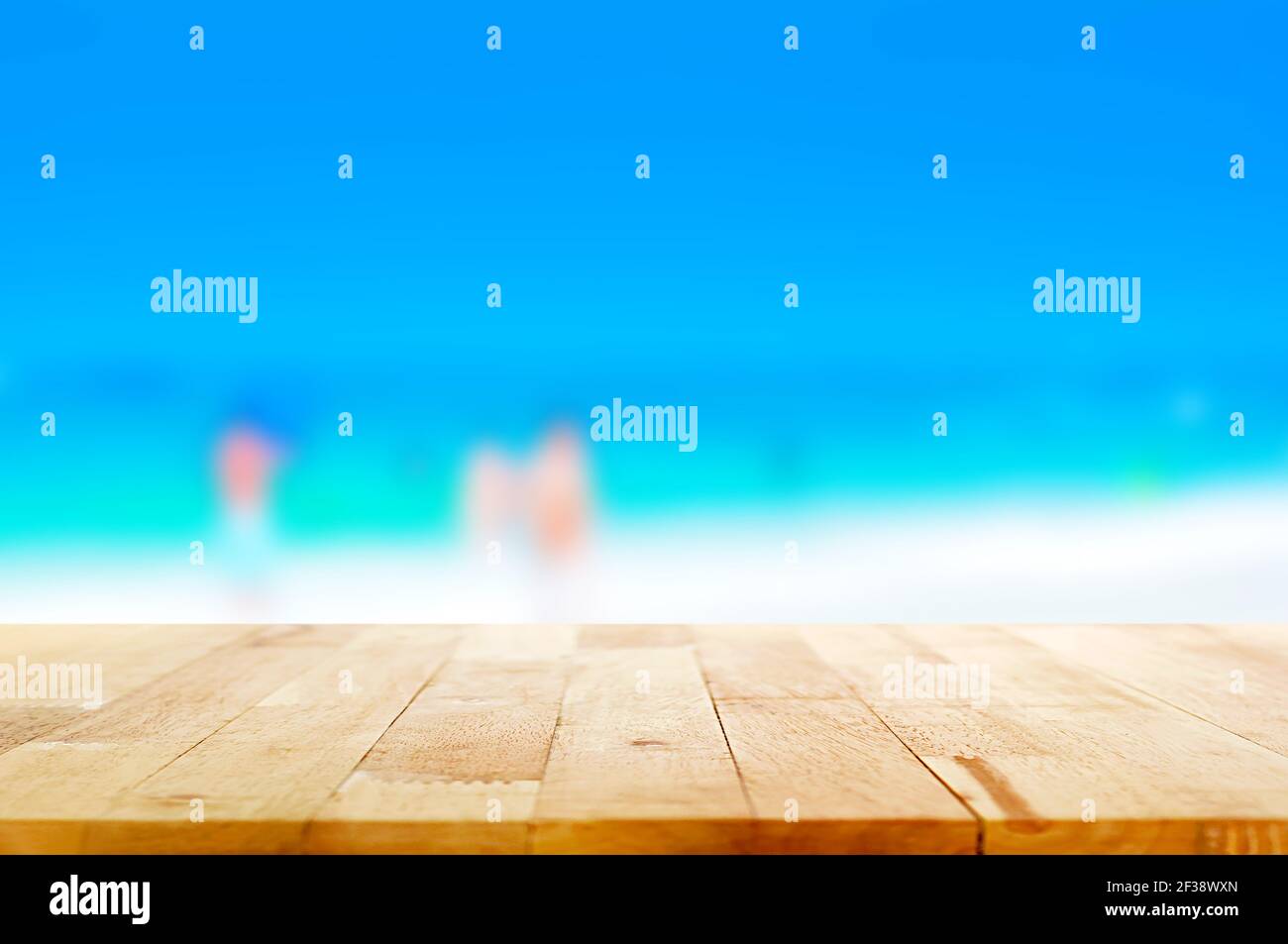 Holztischplatte auf verschwommenem weißen Sandstrand und blau Meereshintergrund - kann zur Anzeige oder Montage verwendet werden Ihre Produkte Stockfoto