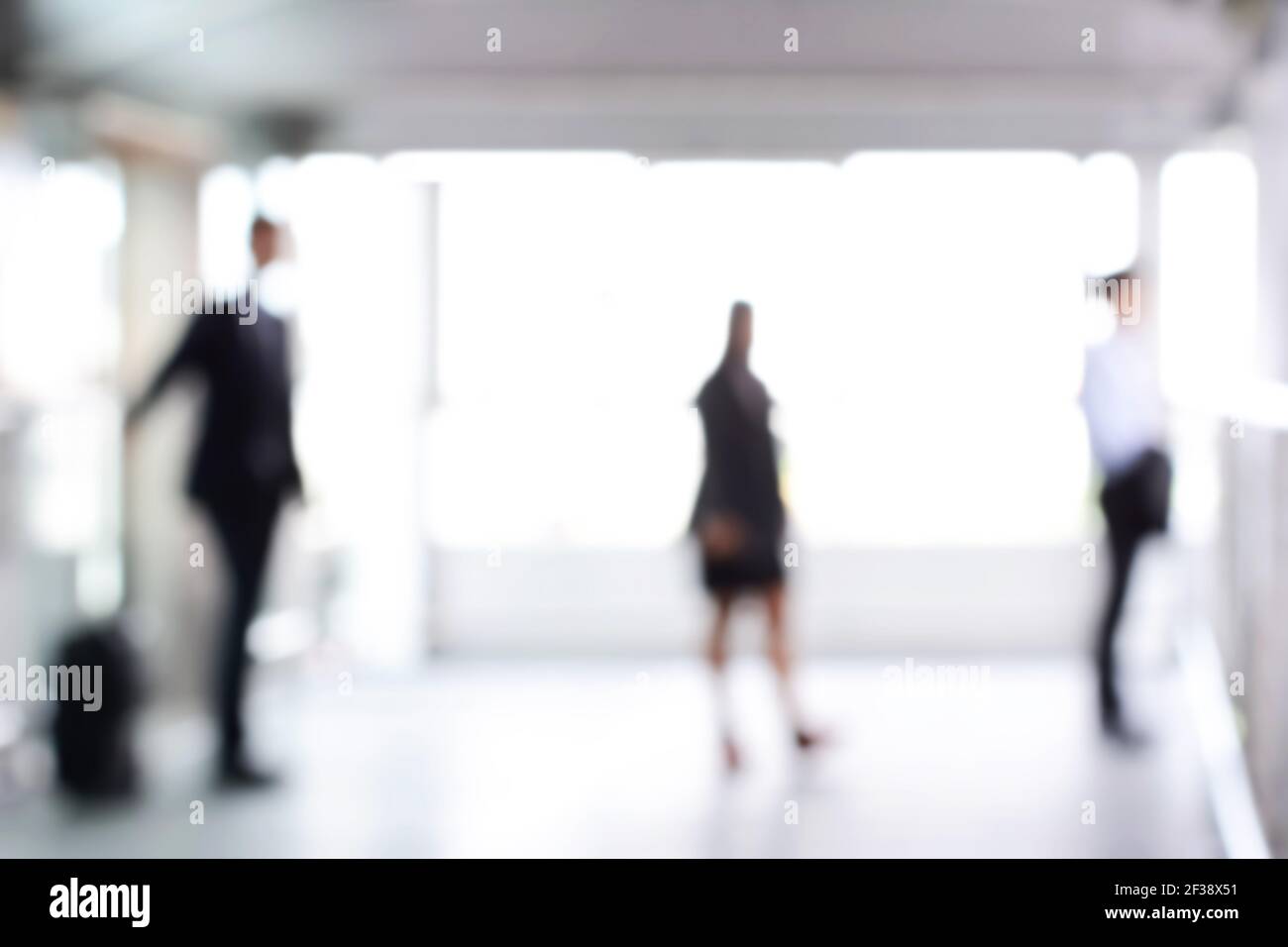 Verschwommene Geschäftsleute, die in der Halle stehen, können als abstrakter Hintergrund verwendet werden Stockfoto